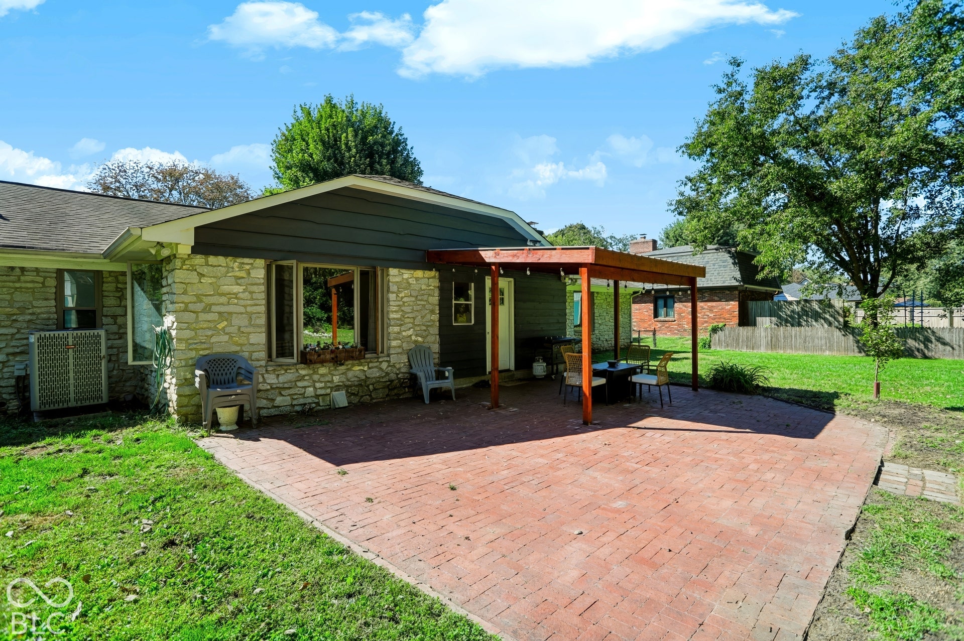 Expansive brick paver patio with a wood pergola