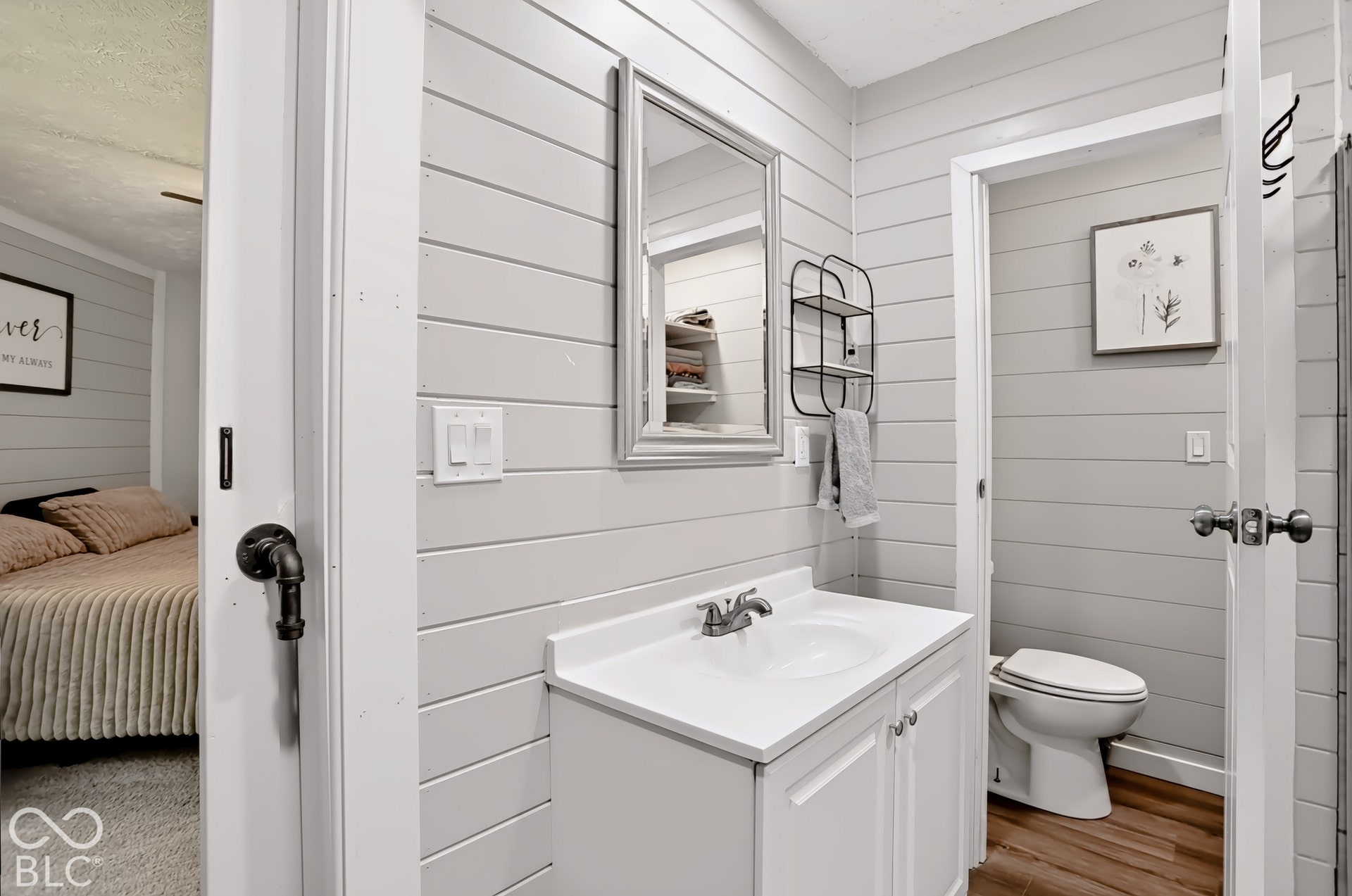 Bathroom featuring a vanity with an integrated sink, built-in cabinetry, and wood-finish flooring