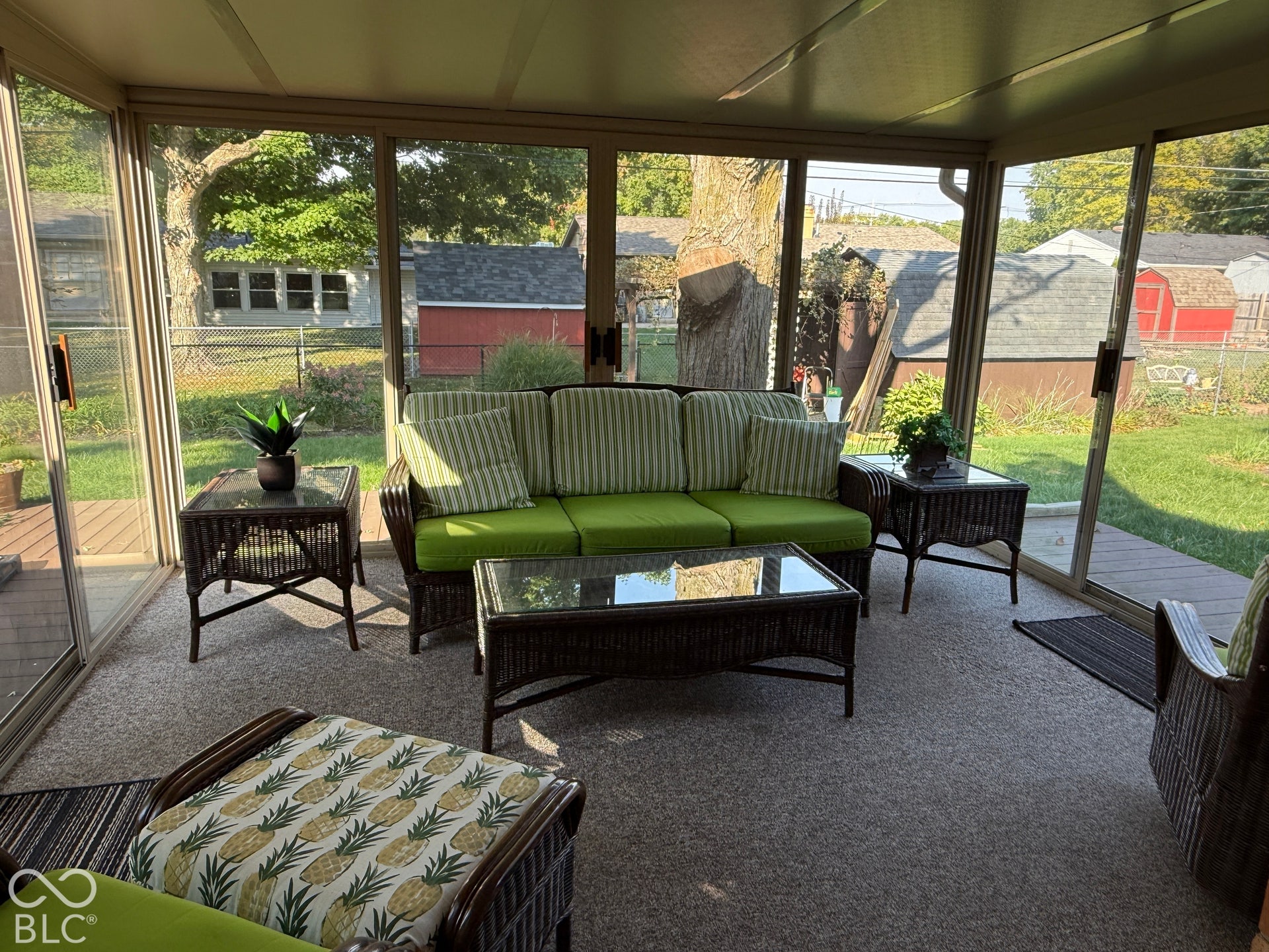 Enclosed sunroom featuring a carpeted floor, screened panels, and direct access to an outdoor deck