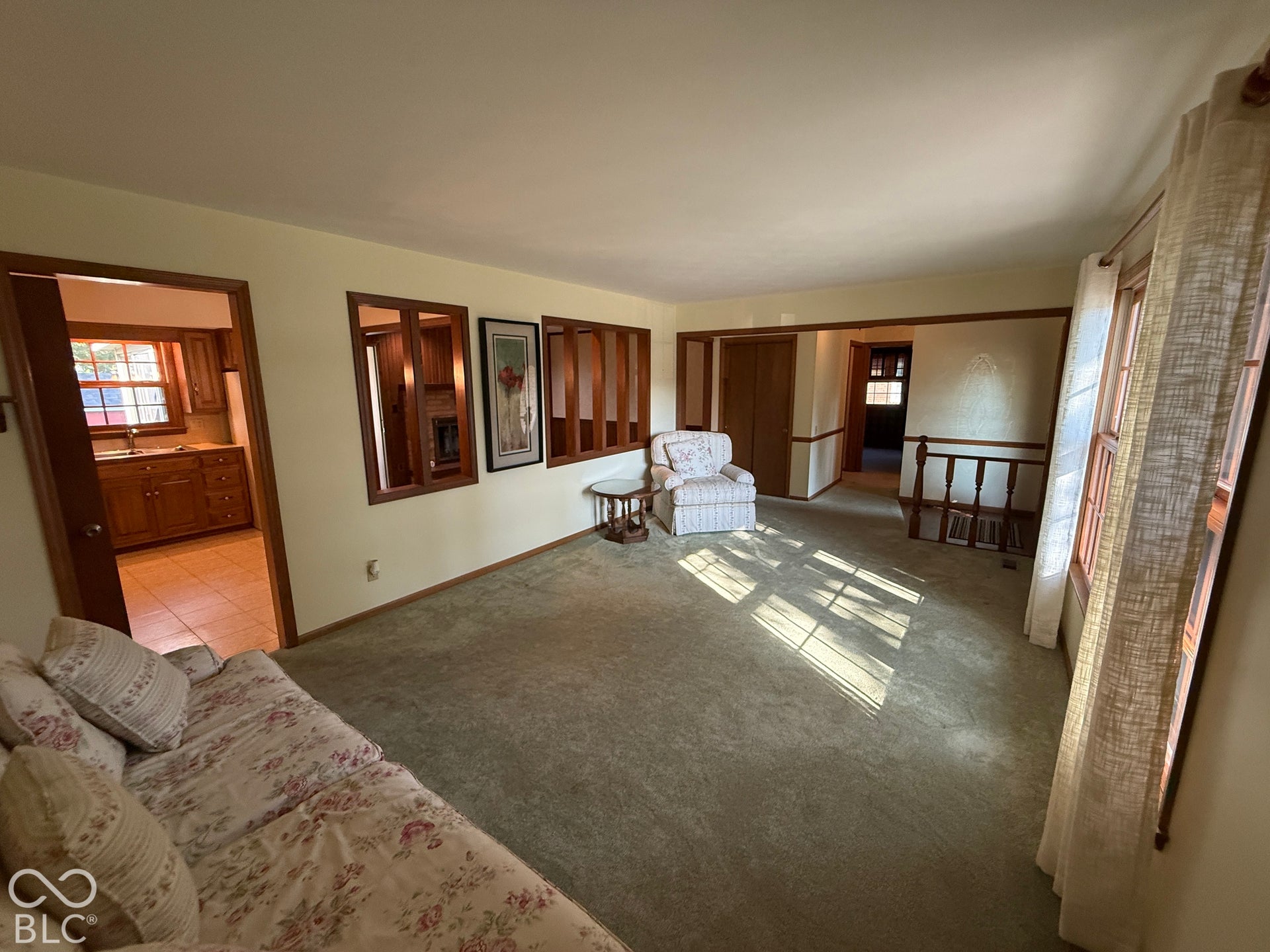 Carpeting throughout, wood-framed windows, and a doorway with wood trim