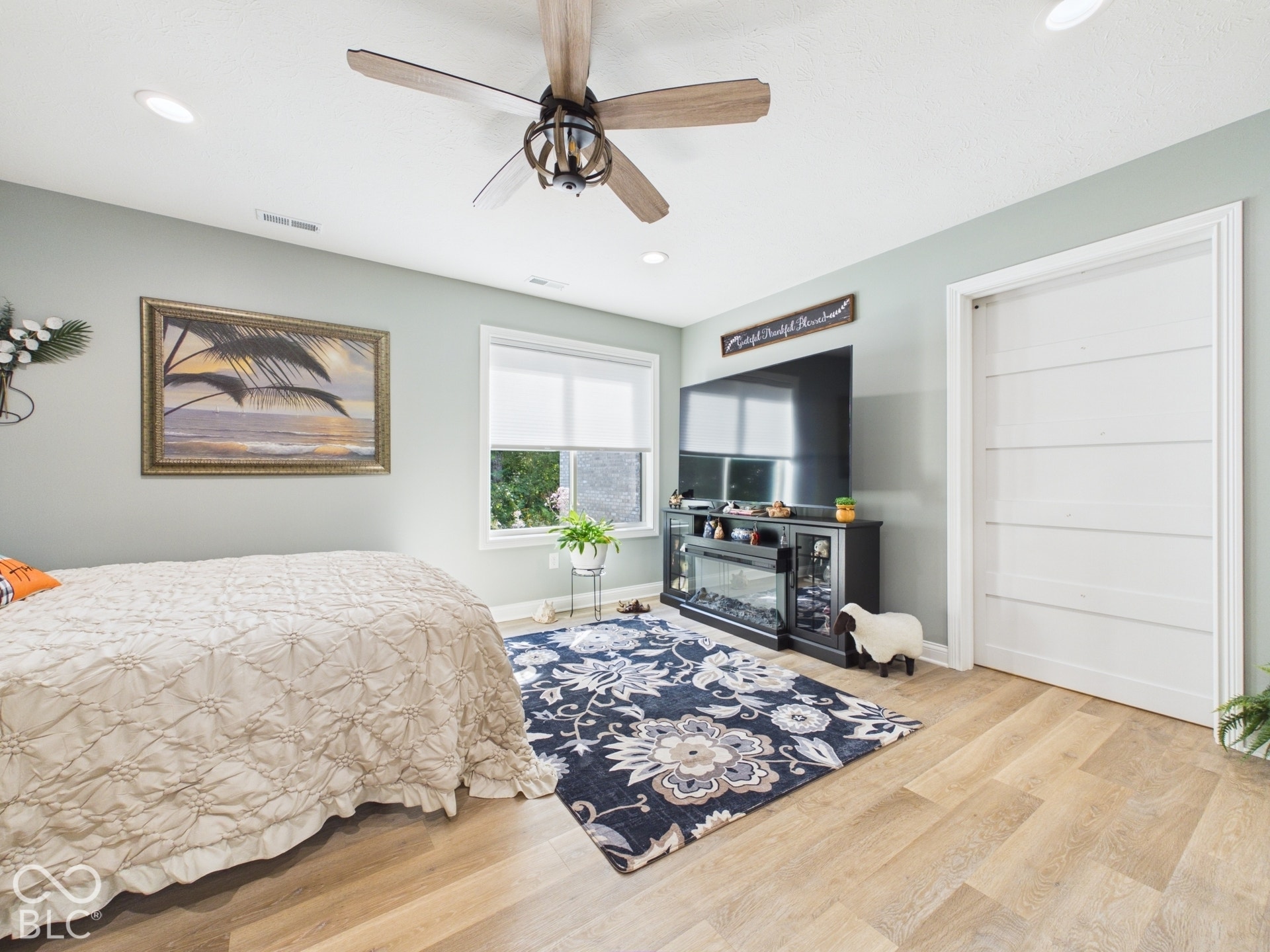 Recessed ceiling lighting, wood-finish flooring, ceiling fan with light fixture, and a white paneled door