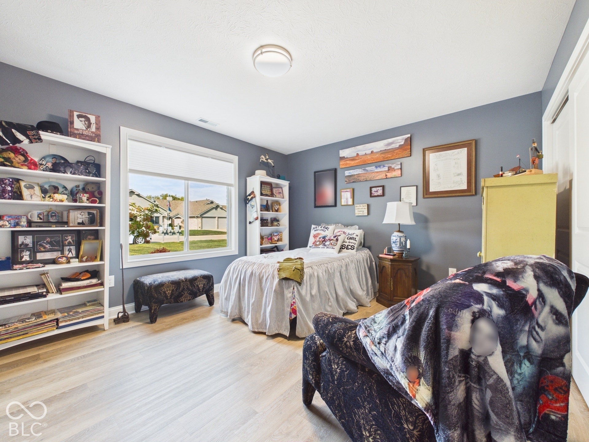 Light wood-finish flooring with a large window providing natural light