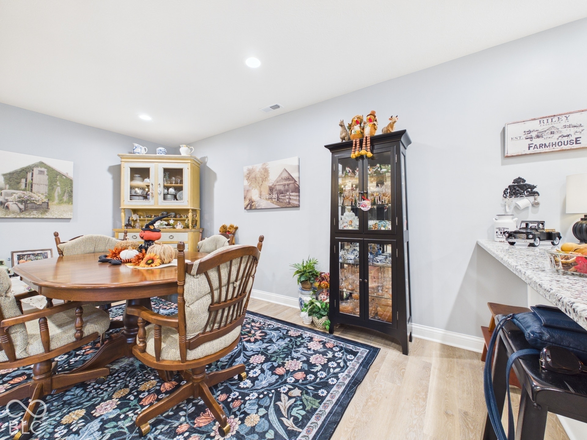 Recessed lighting, light wood-finish flooring, light gray wall paint, and white baseboards
