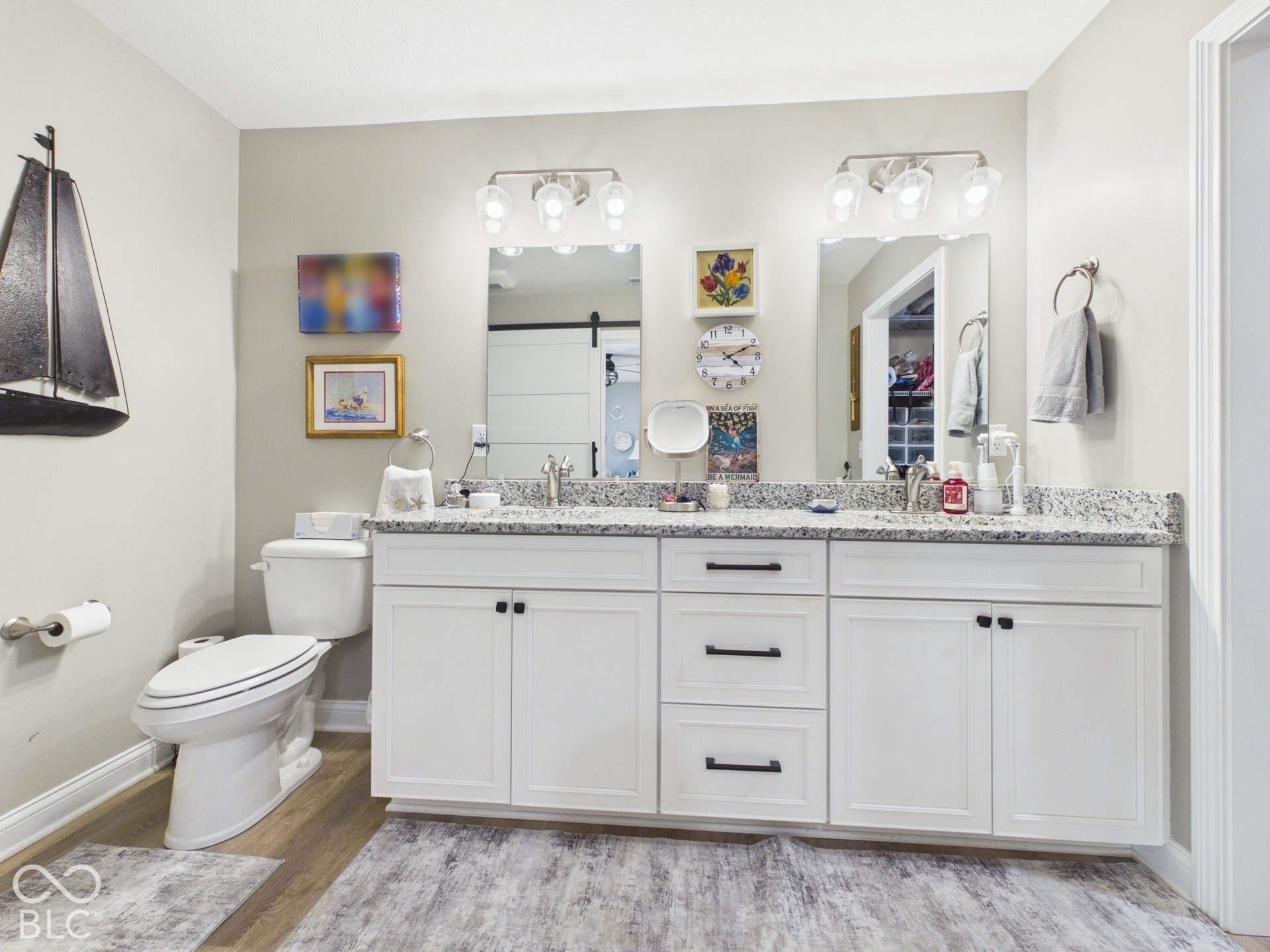 Dual vanity with white cabinetry, matte black hardware, and speckled countertops