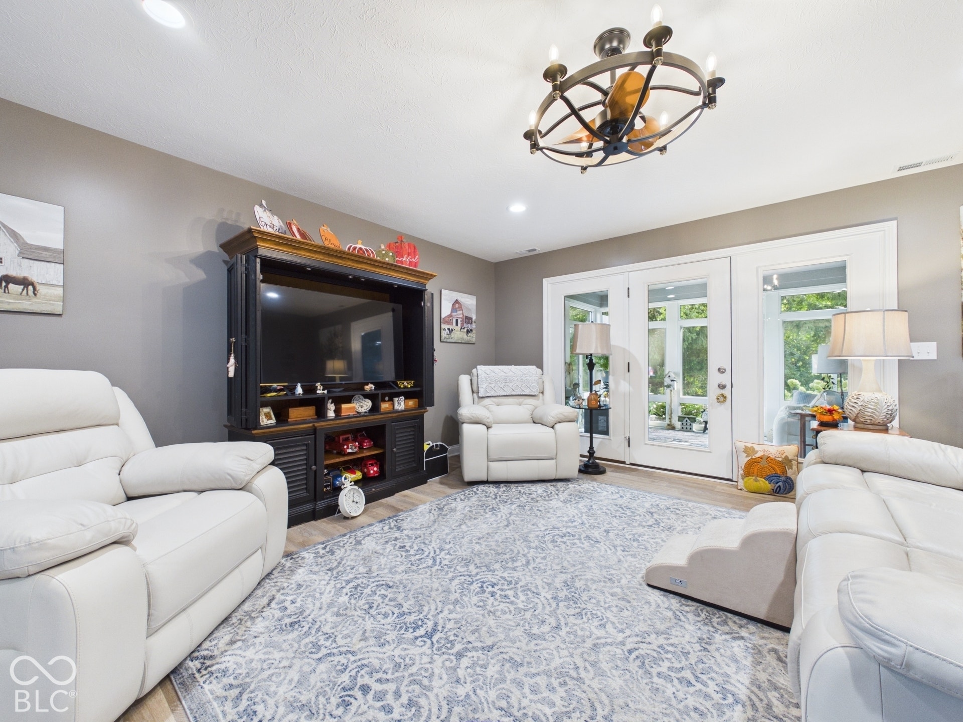 Recessed ceiling lights, wood-finish flooring, and a decorative ceiling fan with integrated lighting