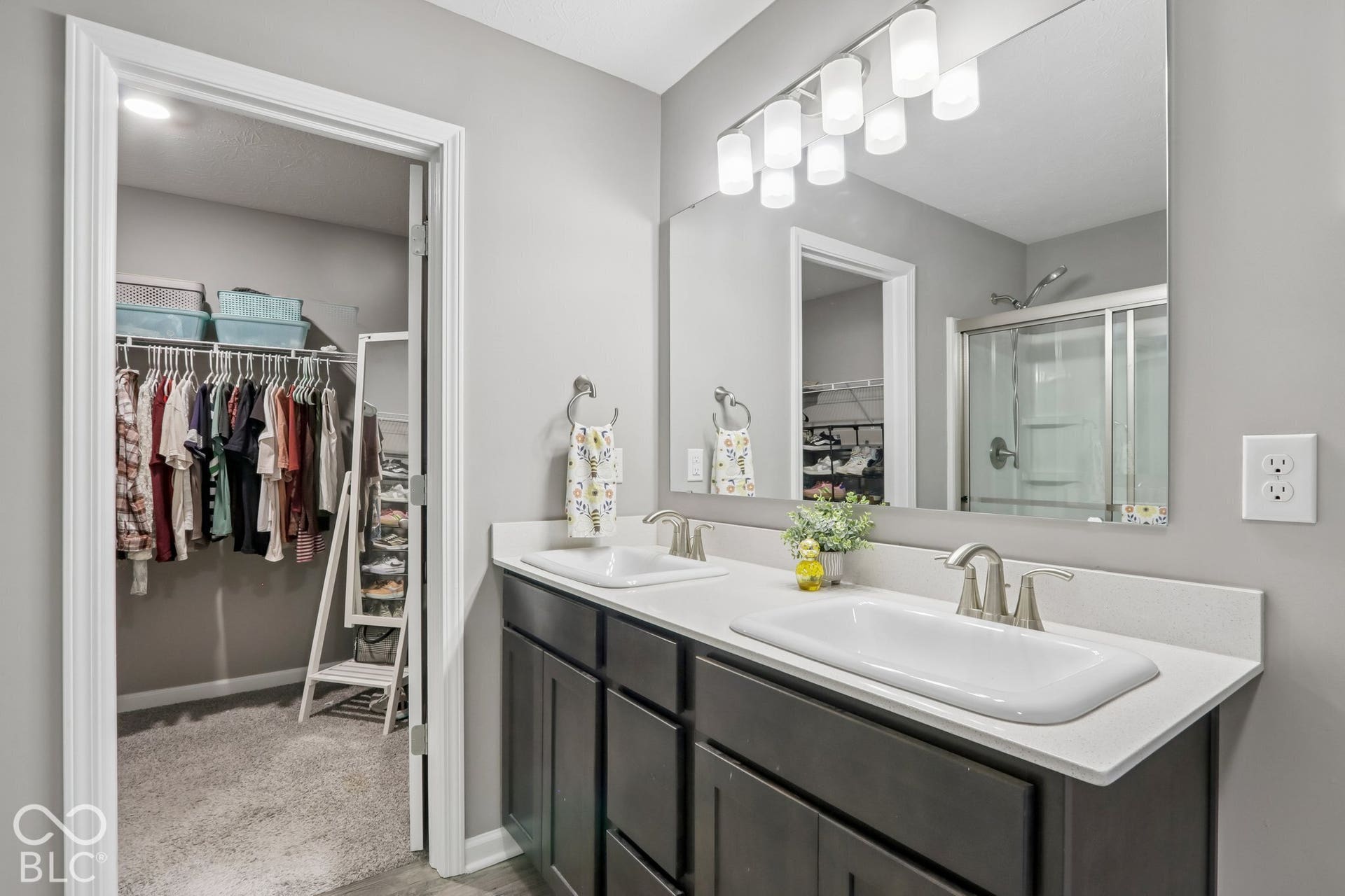 Dual vanity with white rectangular sinks and brushed nickel faucets, dark wood-finish cabinetry