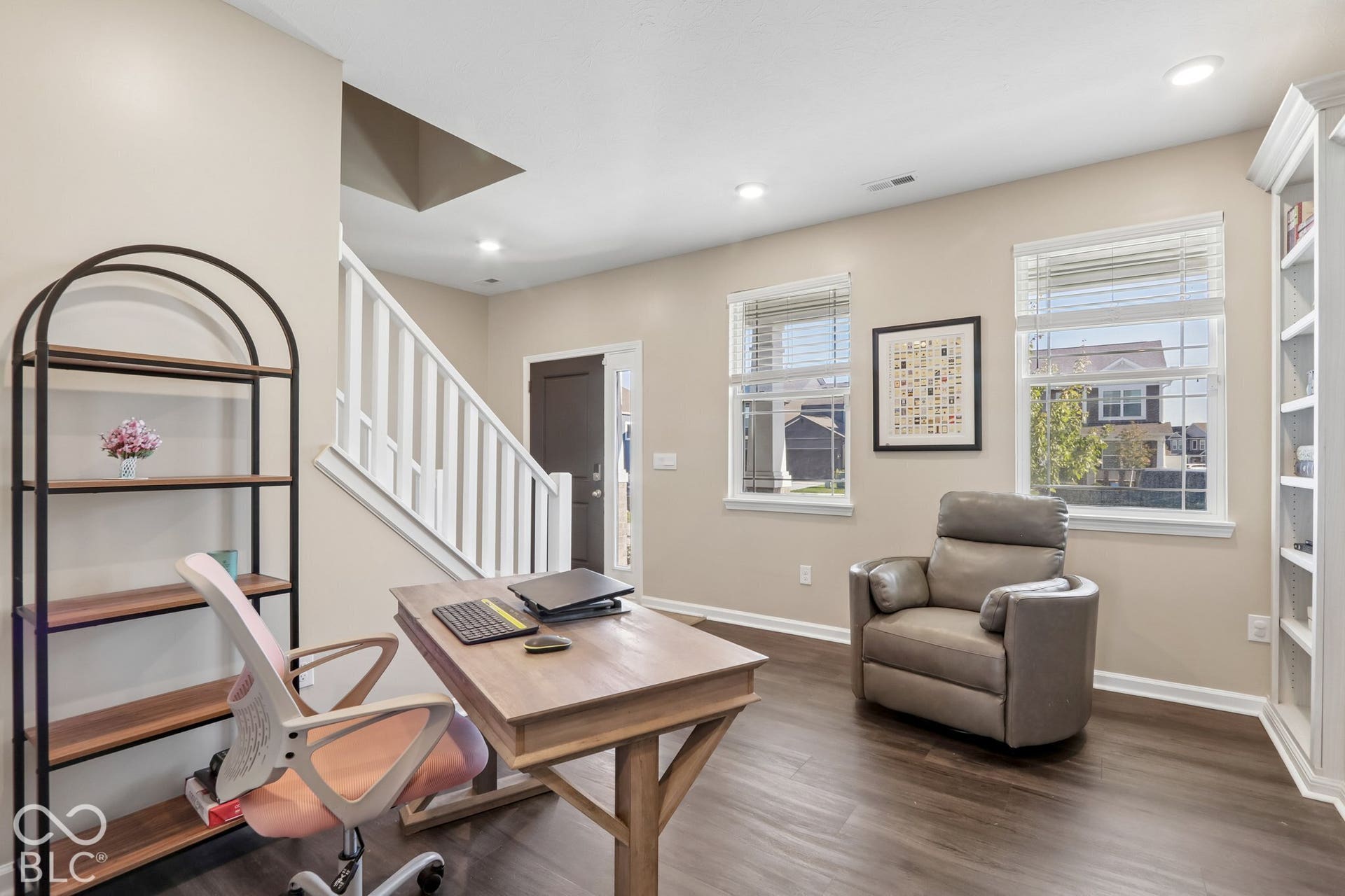 Recessed lighting, wood-finish flooring, white built-in shelving, white window blinds, and white staircase railing
