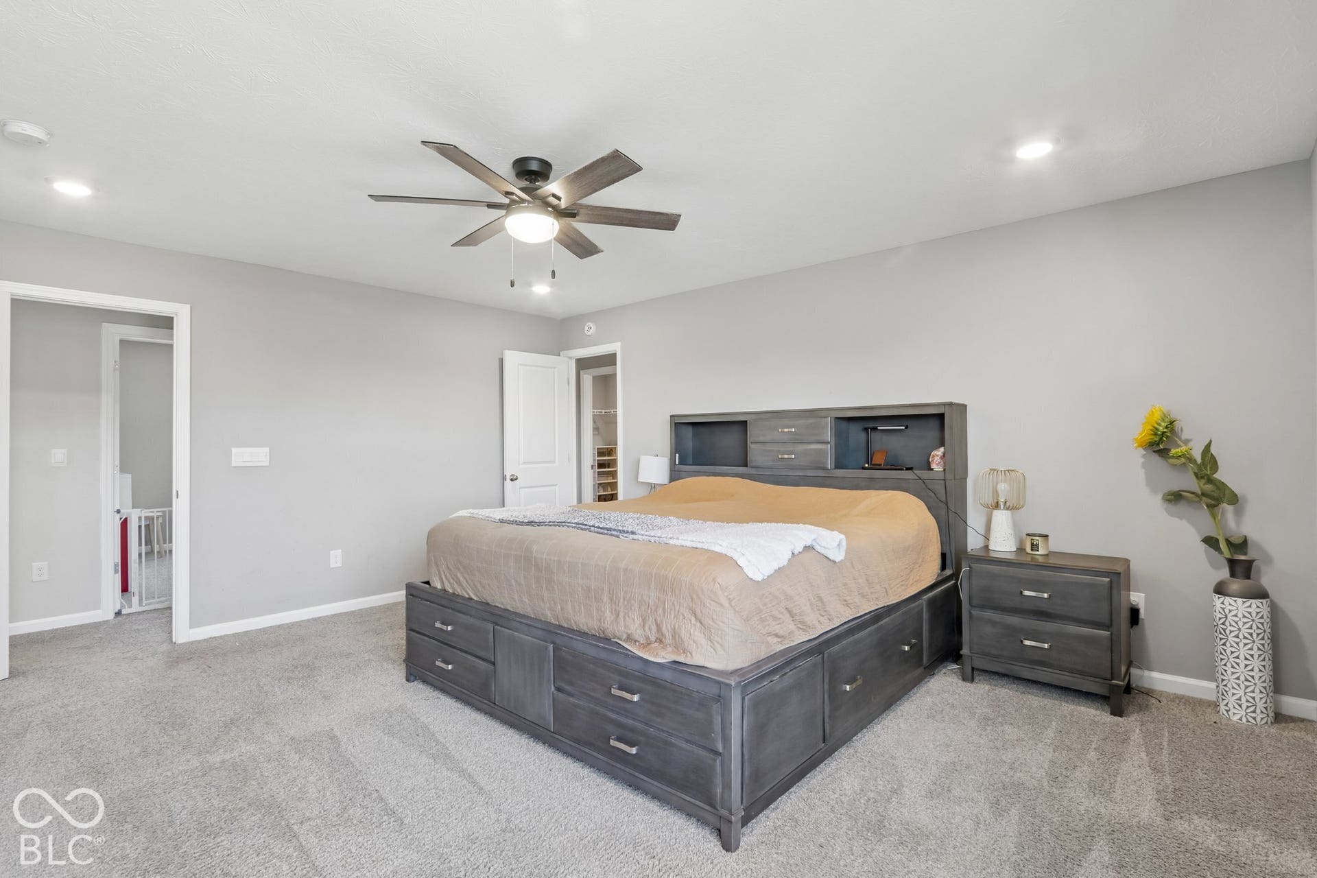 Neutral tone wall paint, recessed ceiling lighting, ceiling fan, and carpeted flooring
