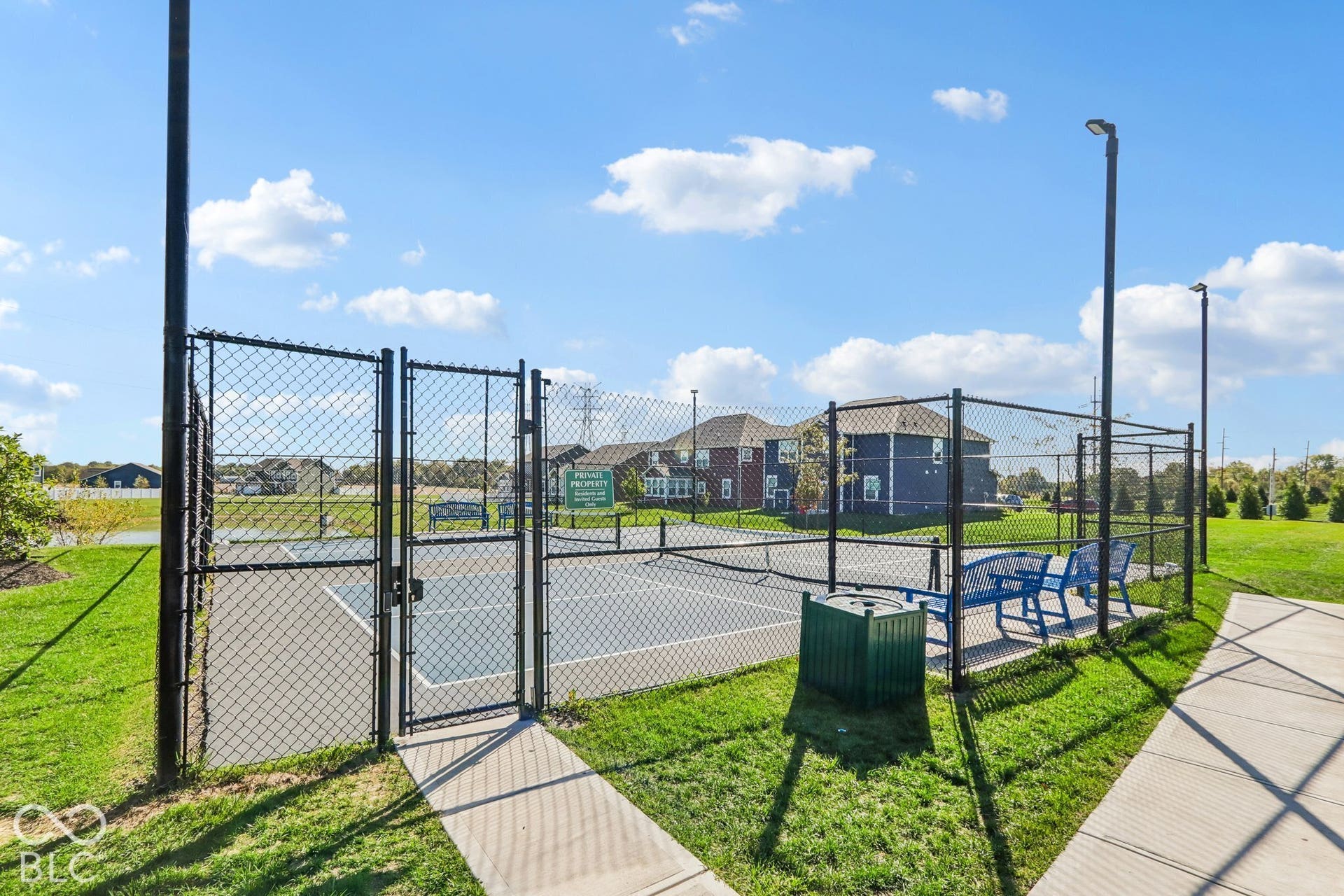Edgewood Farms community fenced Pickleball court with benches and surrounding mature landscaping