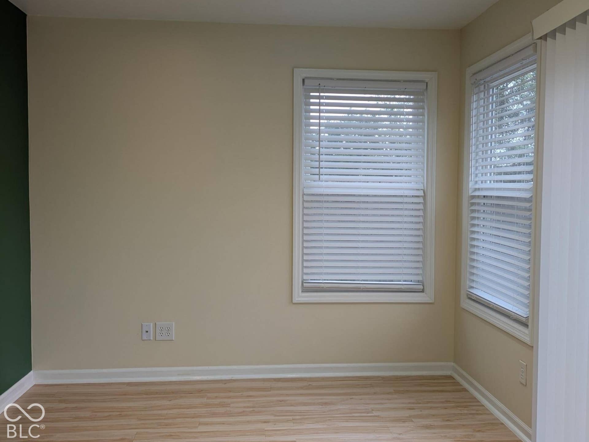 Recessed ceiling lighting, wood-finish flooring, two windows with blinds, and painted walls