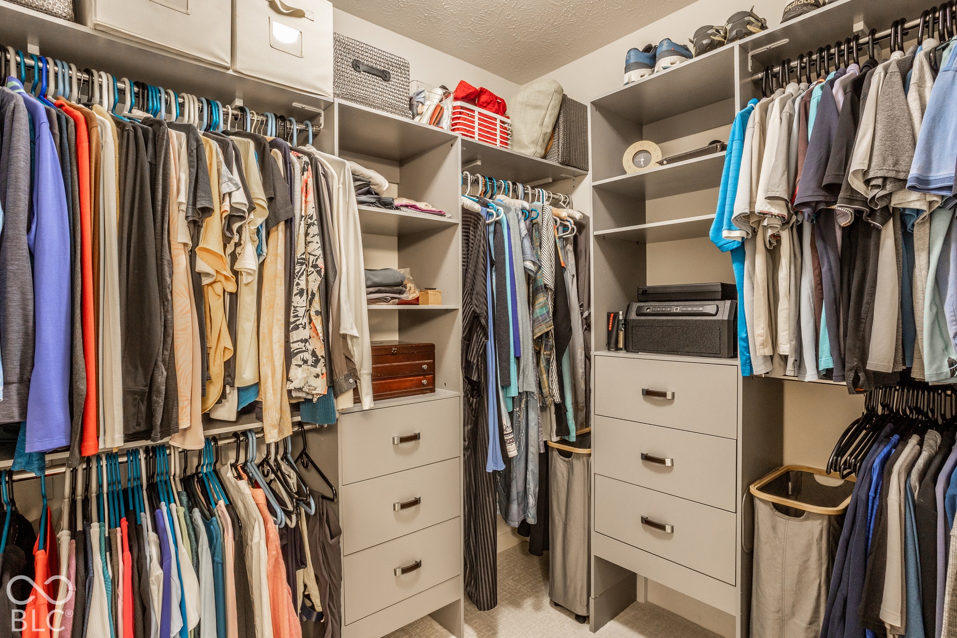 Custom built-in closet system with multiple hanging rods, integrated shelving, and drawer storage