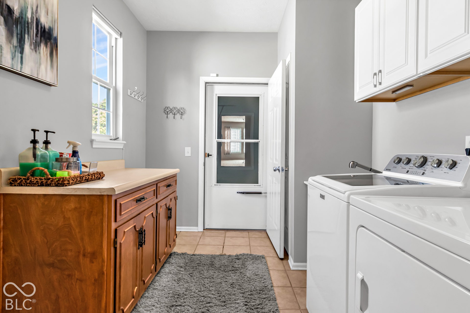 The large laundry room features plenty of additional cabinet space.