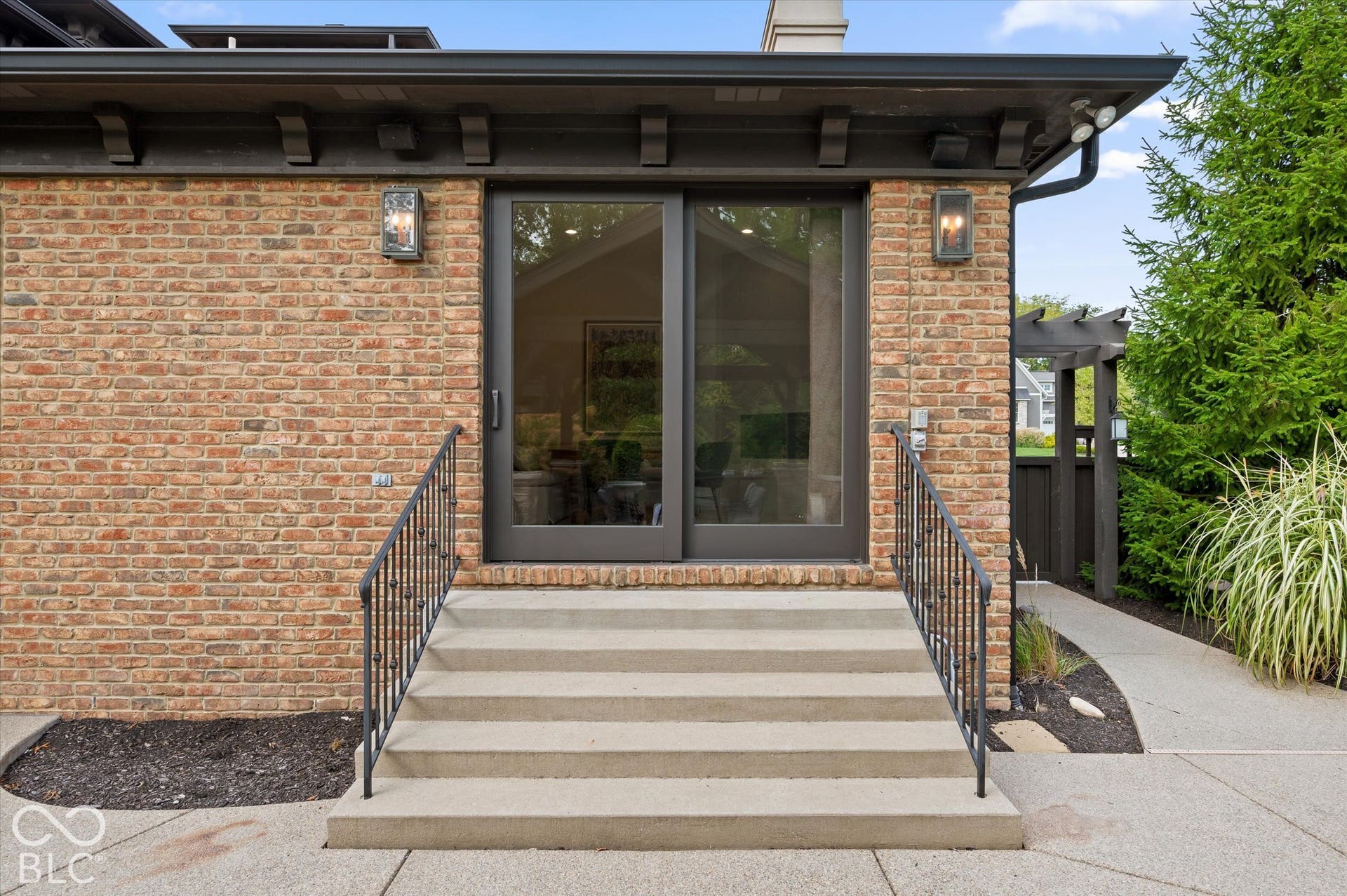 Brick exterior with dark trim and accent lighting