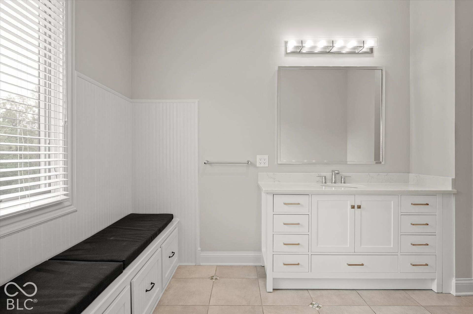 White vanity with a quartz countertop and integrated sink