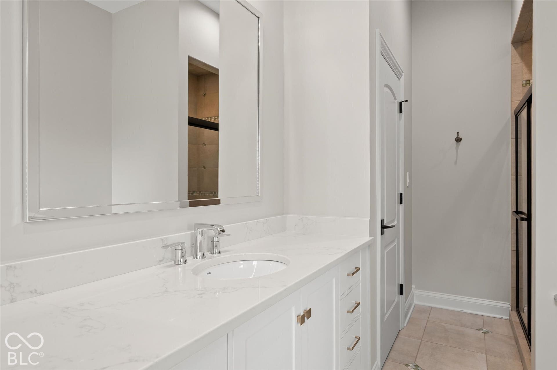 White vanity with integrated sink, polished chrome faucet, and gold-finish hardware