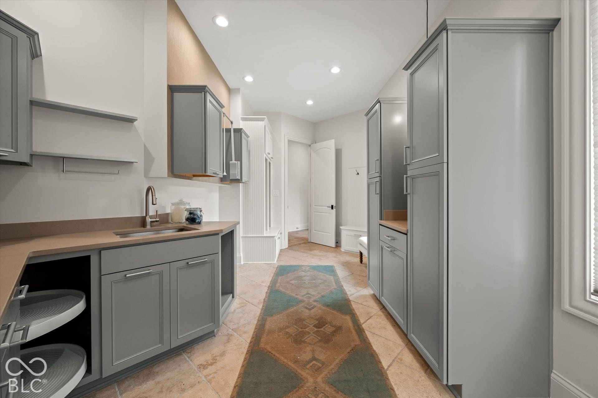 Mudroom featuring full-height cabinetry, stone tile flooring, recessed lighting, and a built-in sink with a countertop