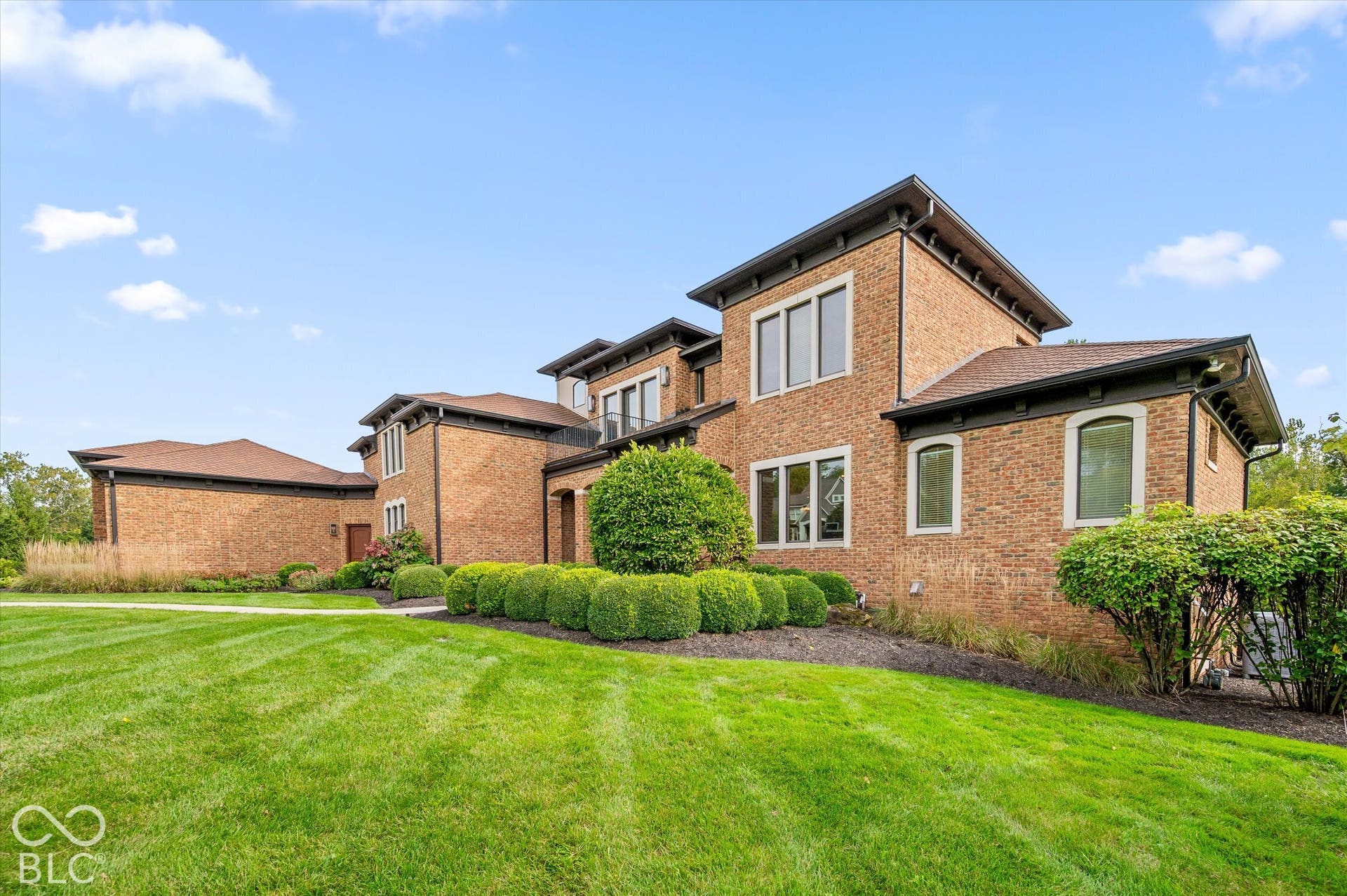 Brick exterior with multiple window styles, dark trim, and a shingled roof
