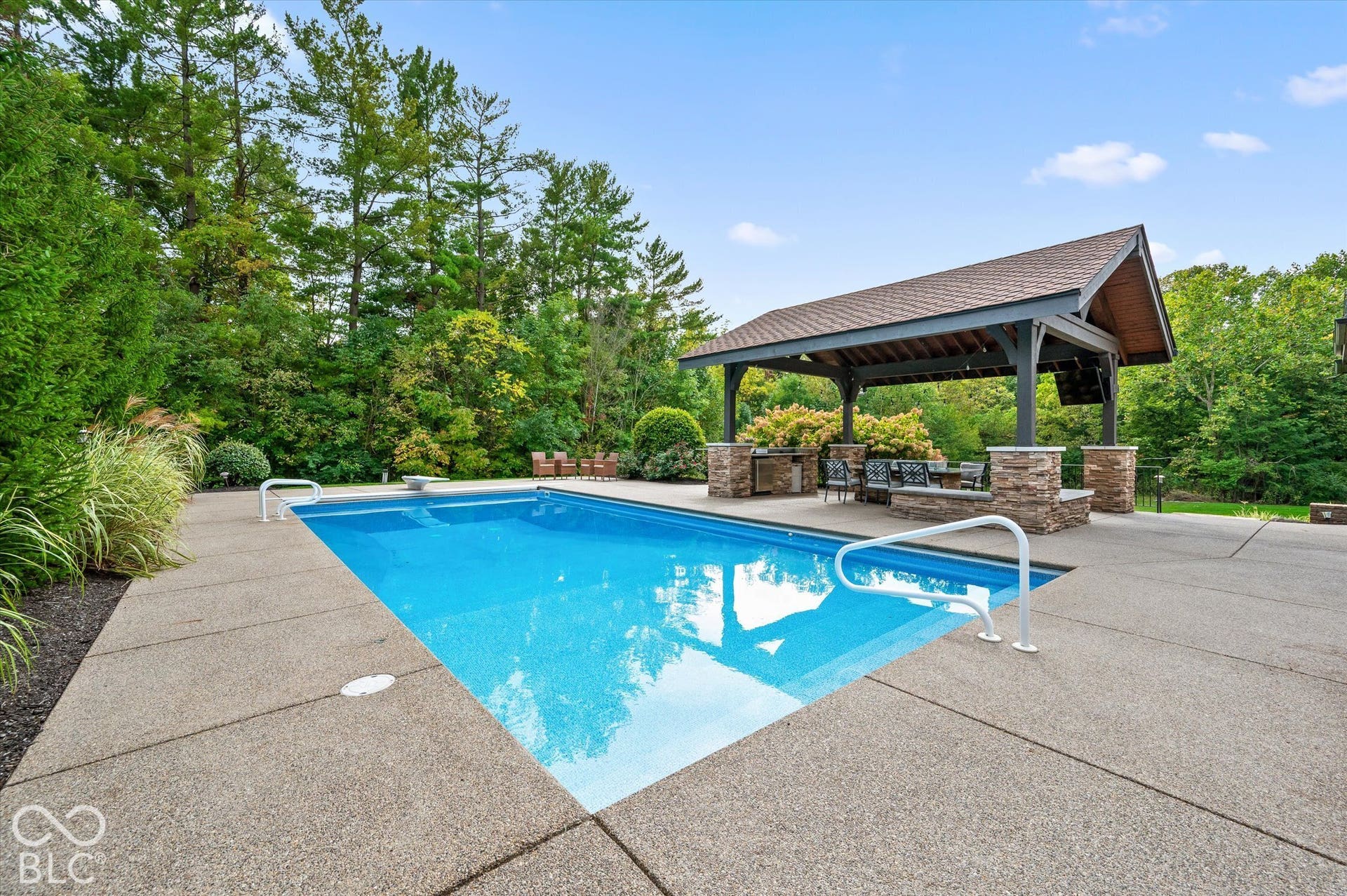 In-ground swimming pool with surrounding concrete decking