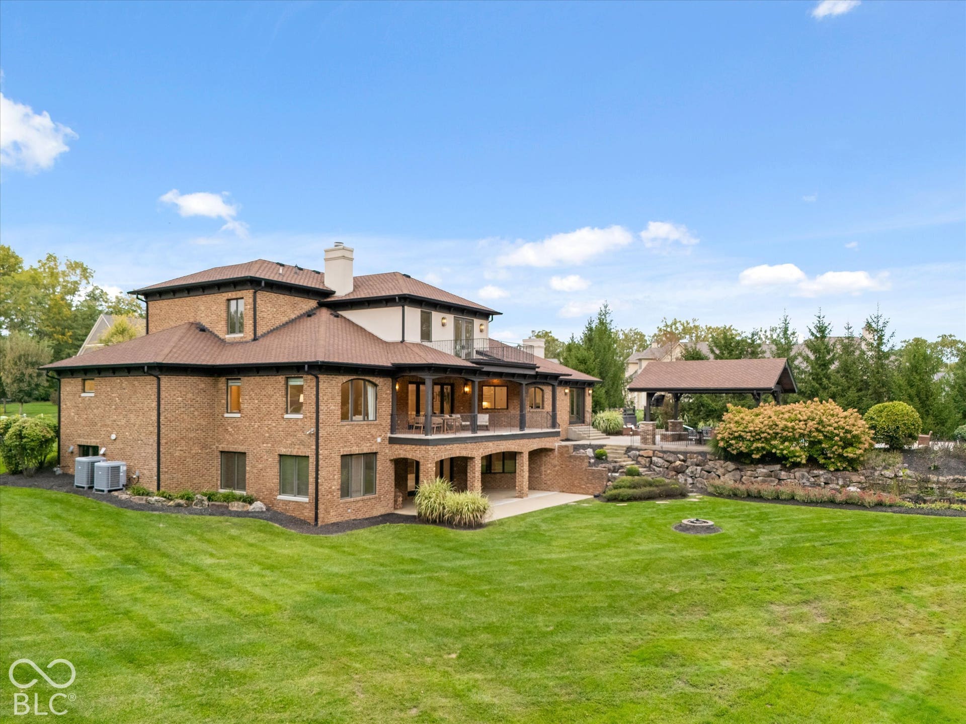 Brick exterior with multiple windows and a covered outdoor patio