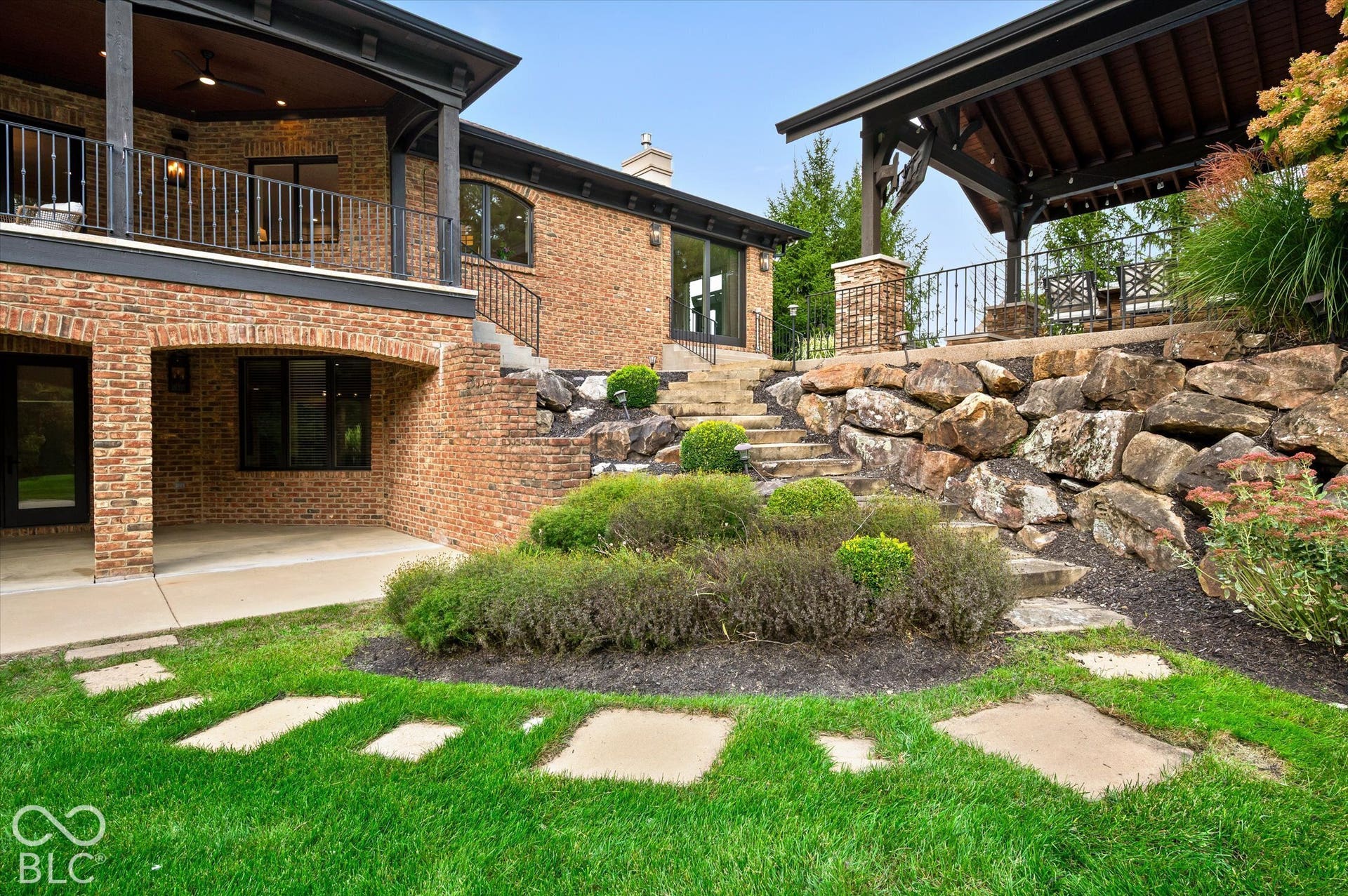 Brick exterior with an elevated covered balcony and an additional covered patio below