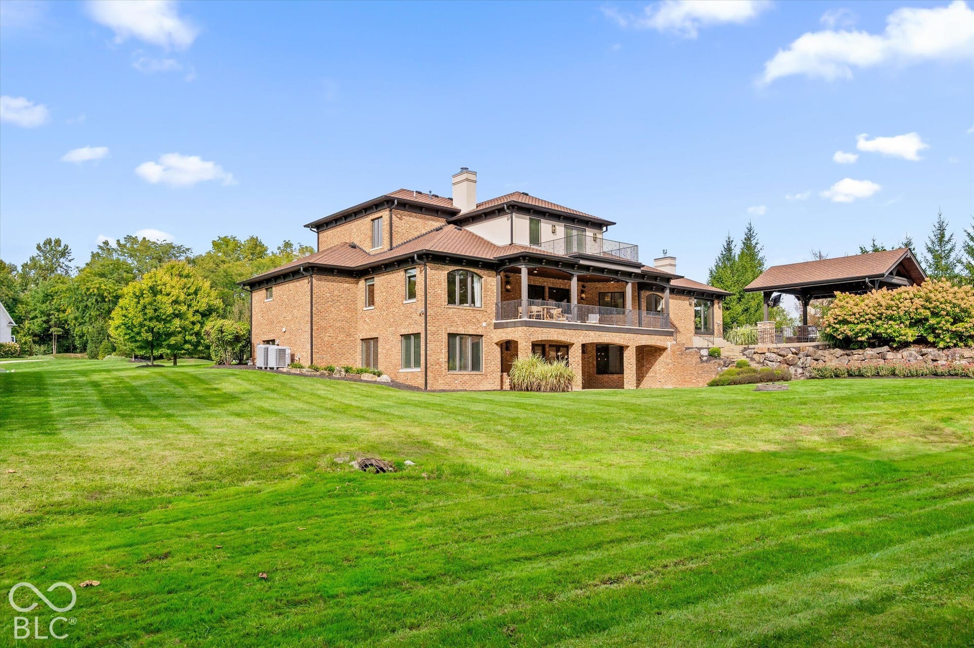 Expansive green lawn with mature trees and landscaping