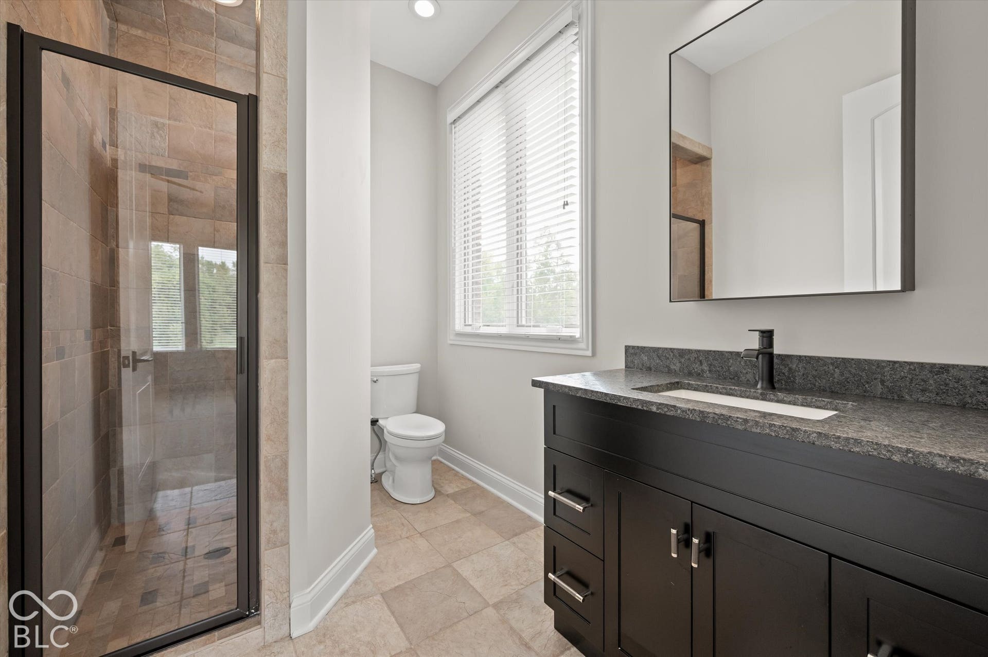 Walk-in shower with clear glass enclosure and tile surround