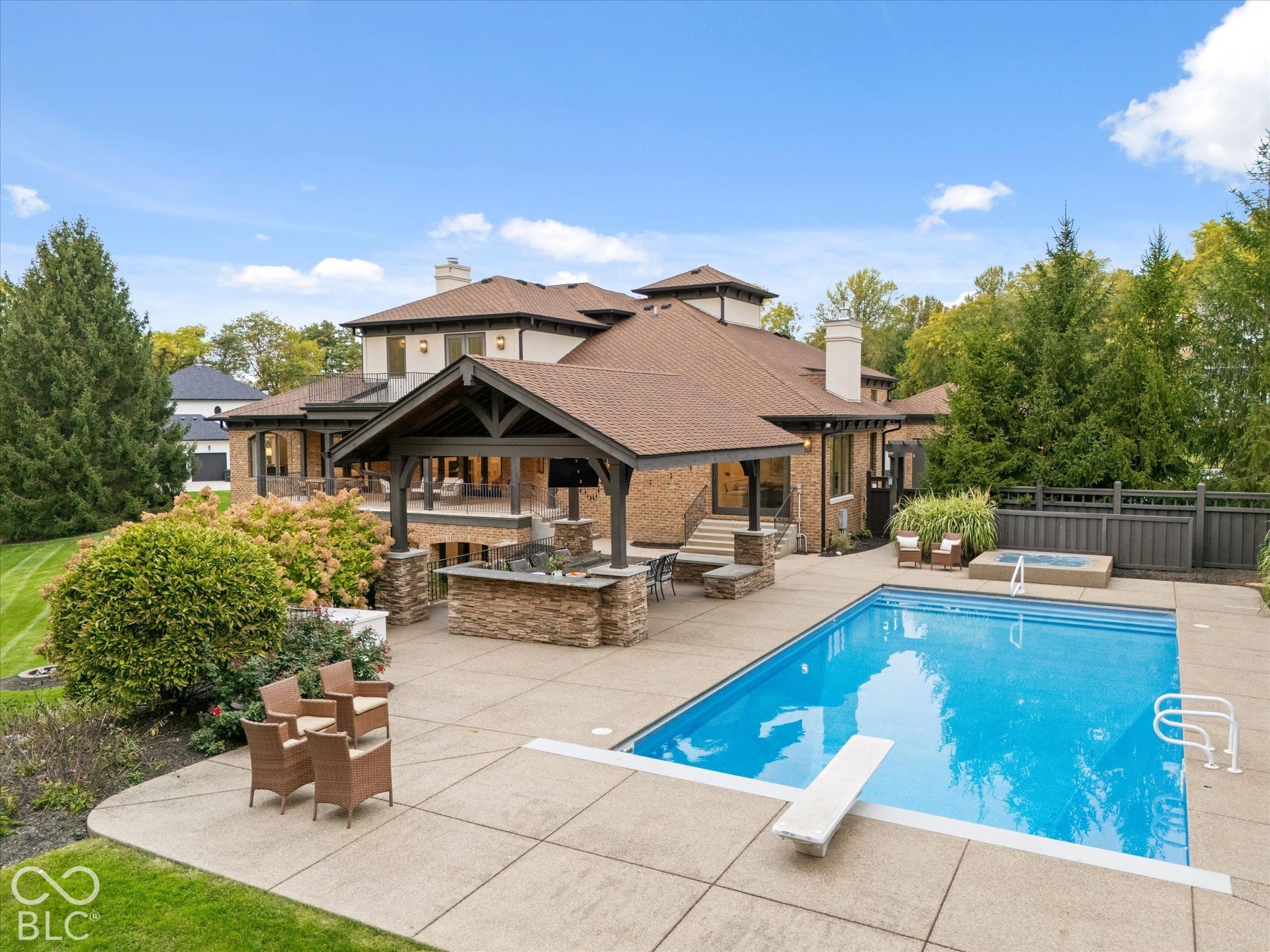 Expansive backyard featuring a large in-ground swimming pool, diving board, and integrated hot tub