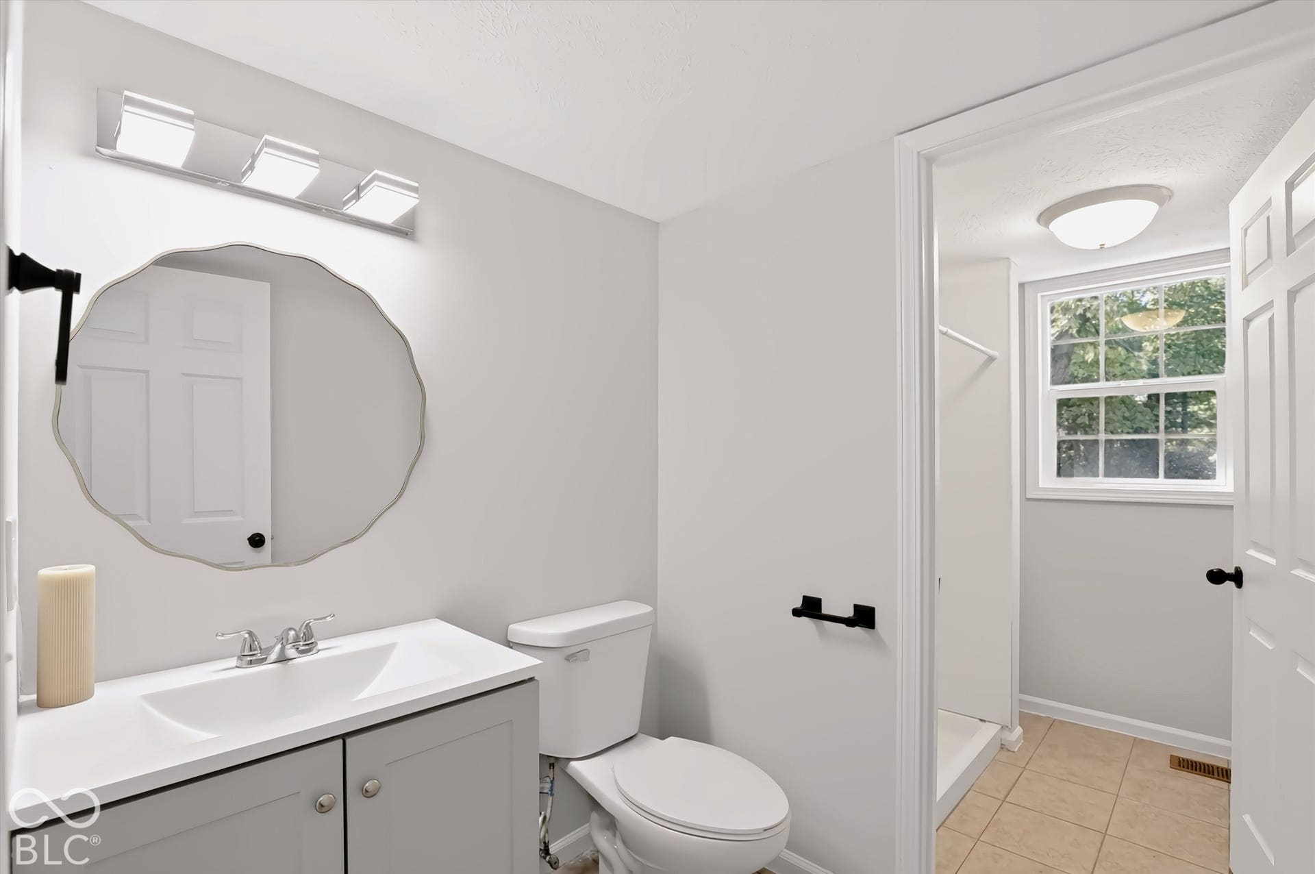Vanity with integrated sink, rectangular mirror, and modern three-light fixture