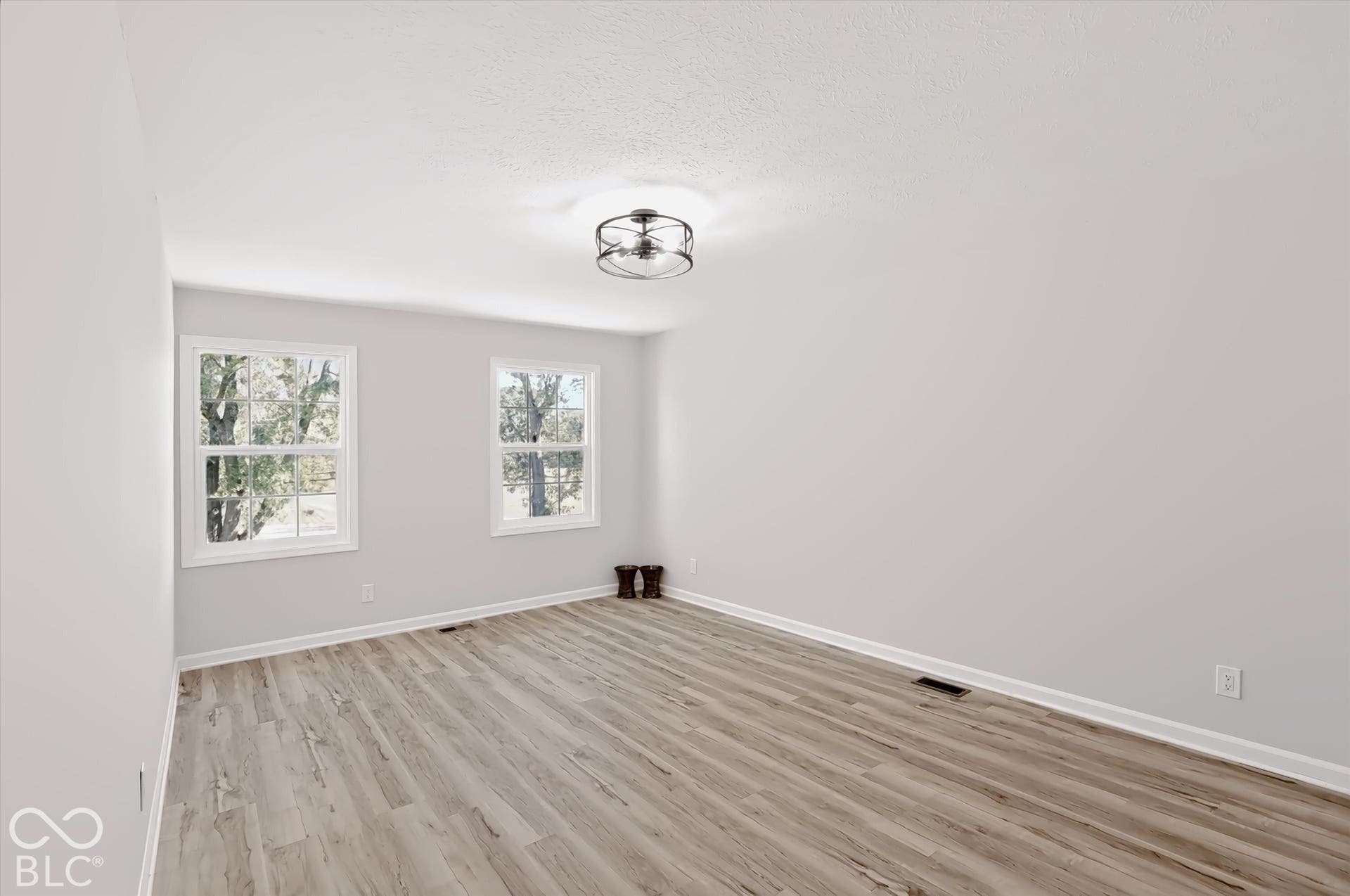 Dual windows, wood-finish flooring, recessed lighting, and a contemporary ceiling fixture
