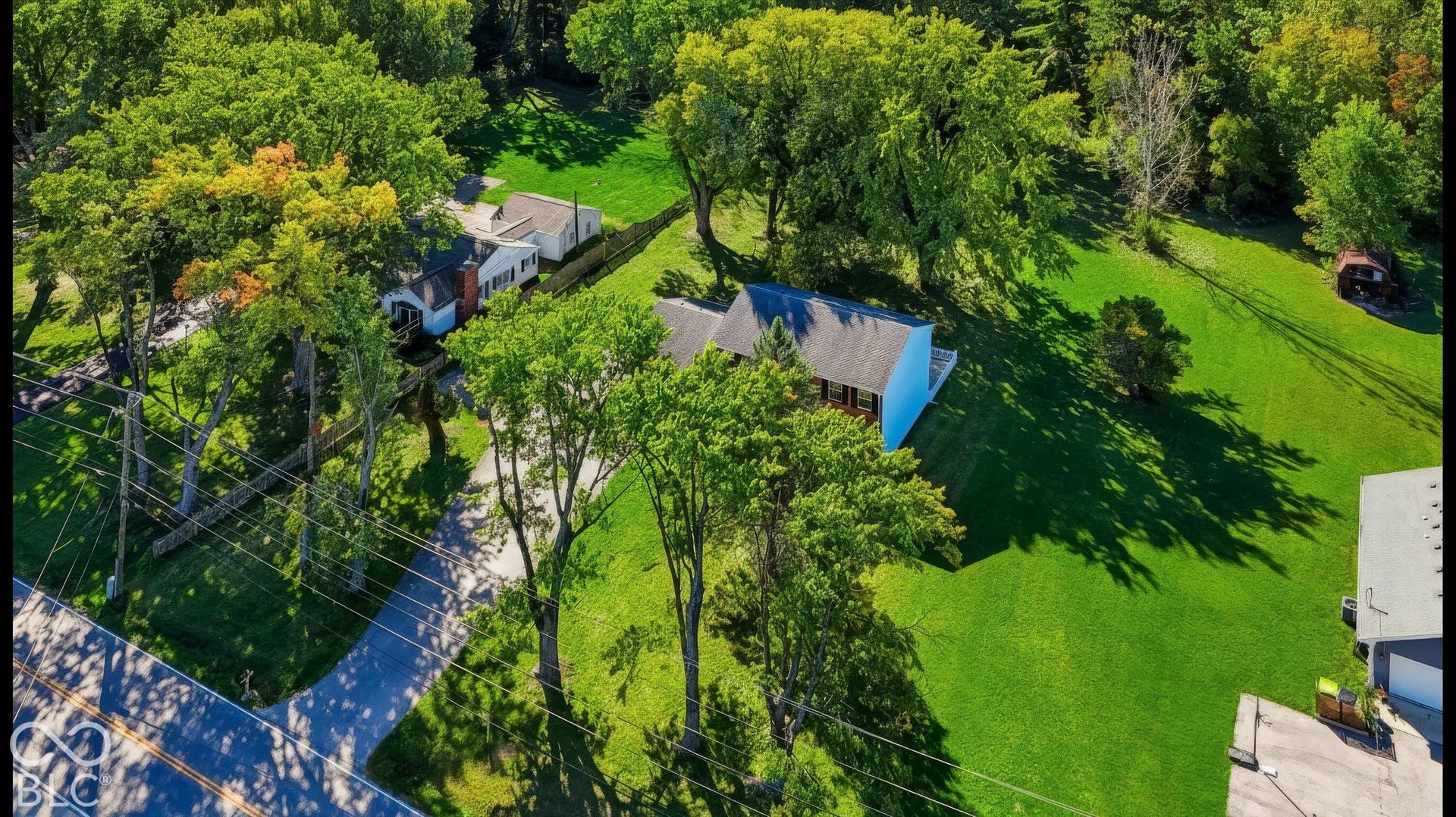 Expansive green spaces featuring mature trees and a residential street