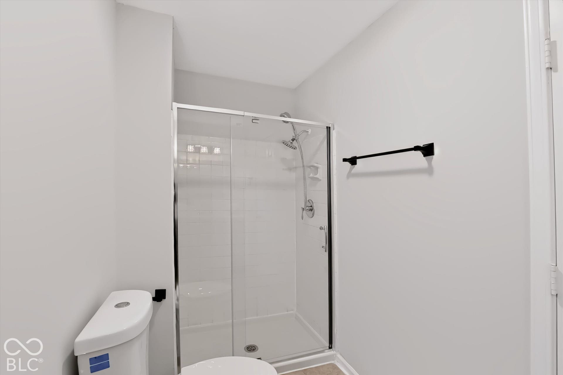 Walk-in shower with clear glass enclosure, subway tile surround, and chrome fixtures