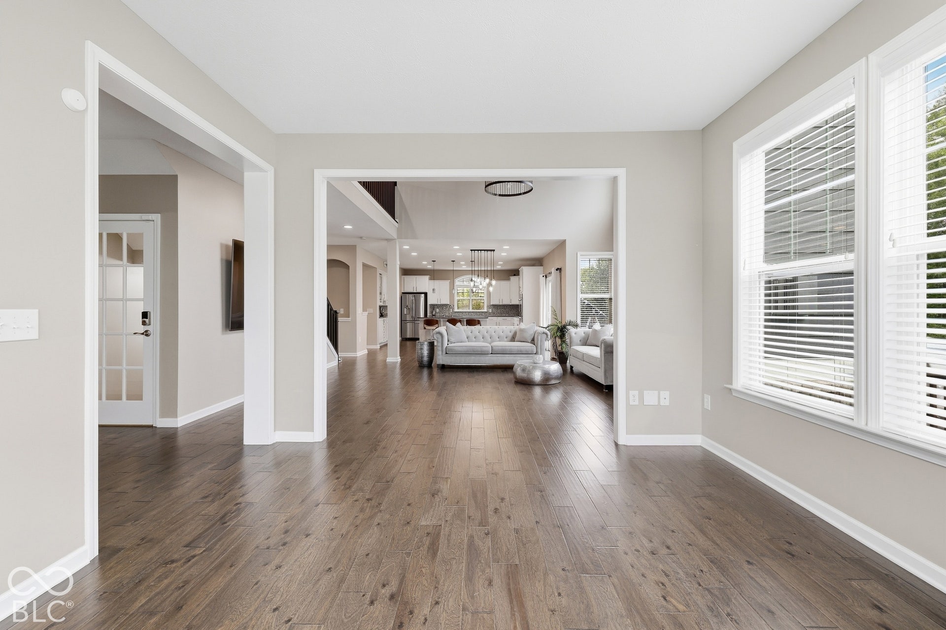 Open-concept layout with wood-finish flooring, white trim, and light-toned walls