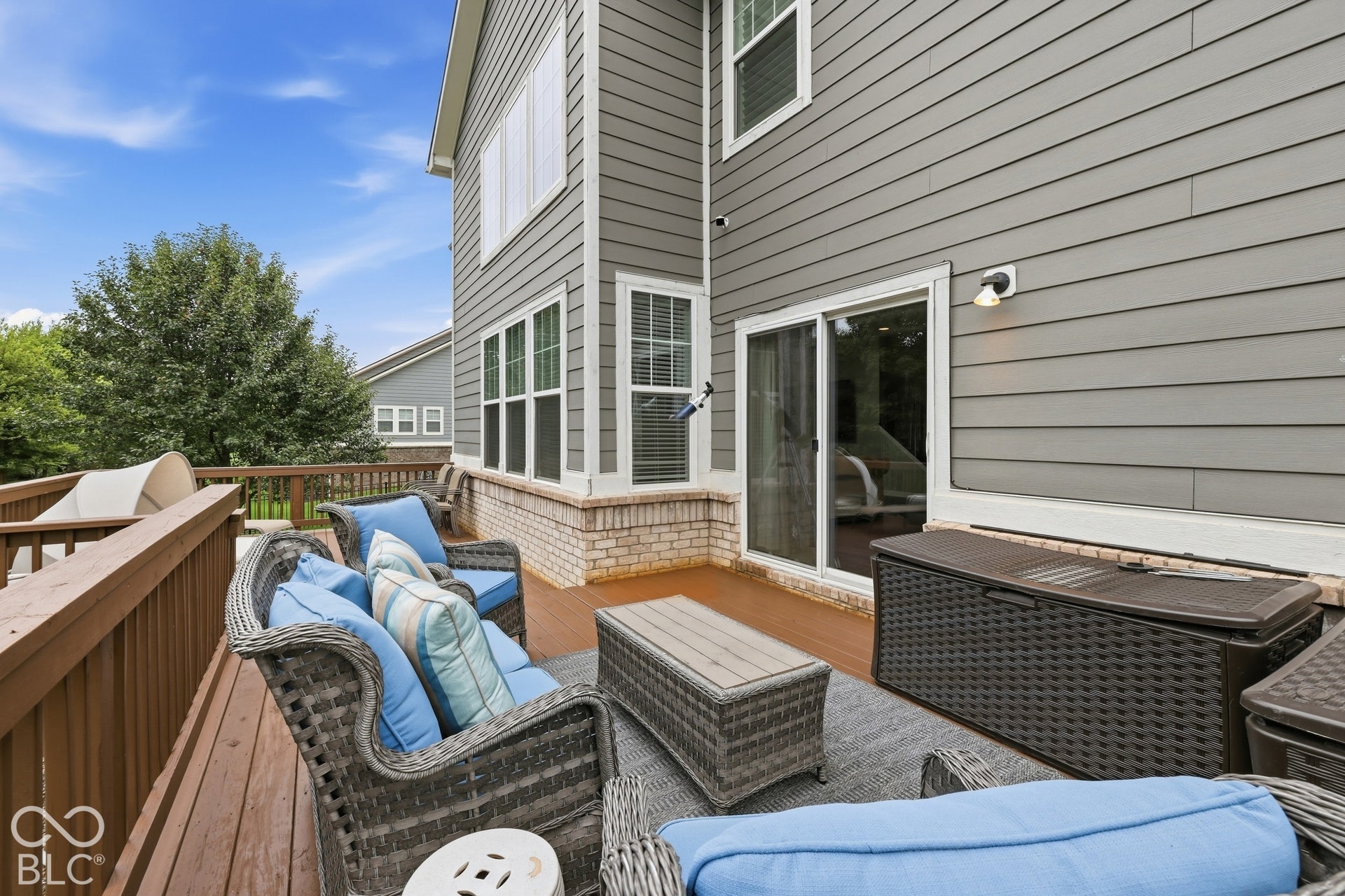 Expansive outdoor deck overlooking a private treeline and fenced yard