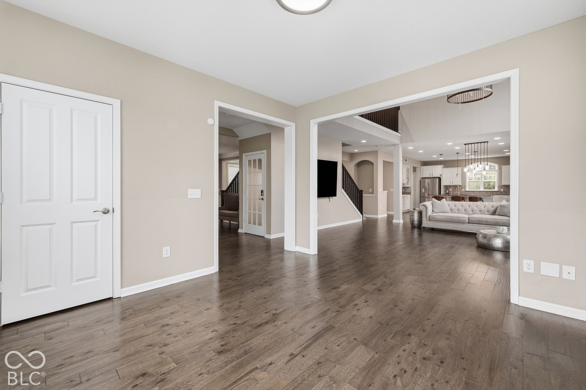 Expansive wood-finish flooring throughout, neutral wall tones, and white trim