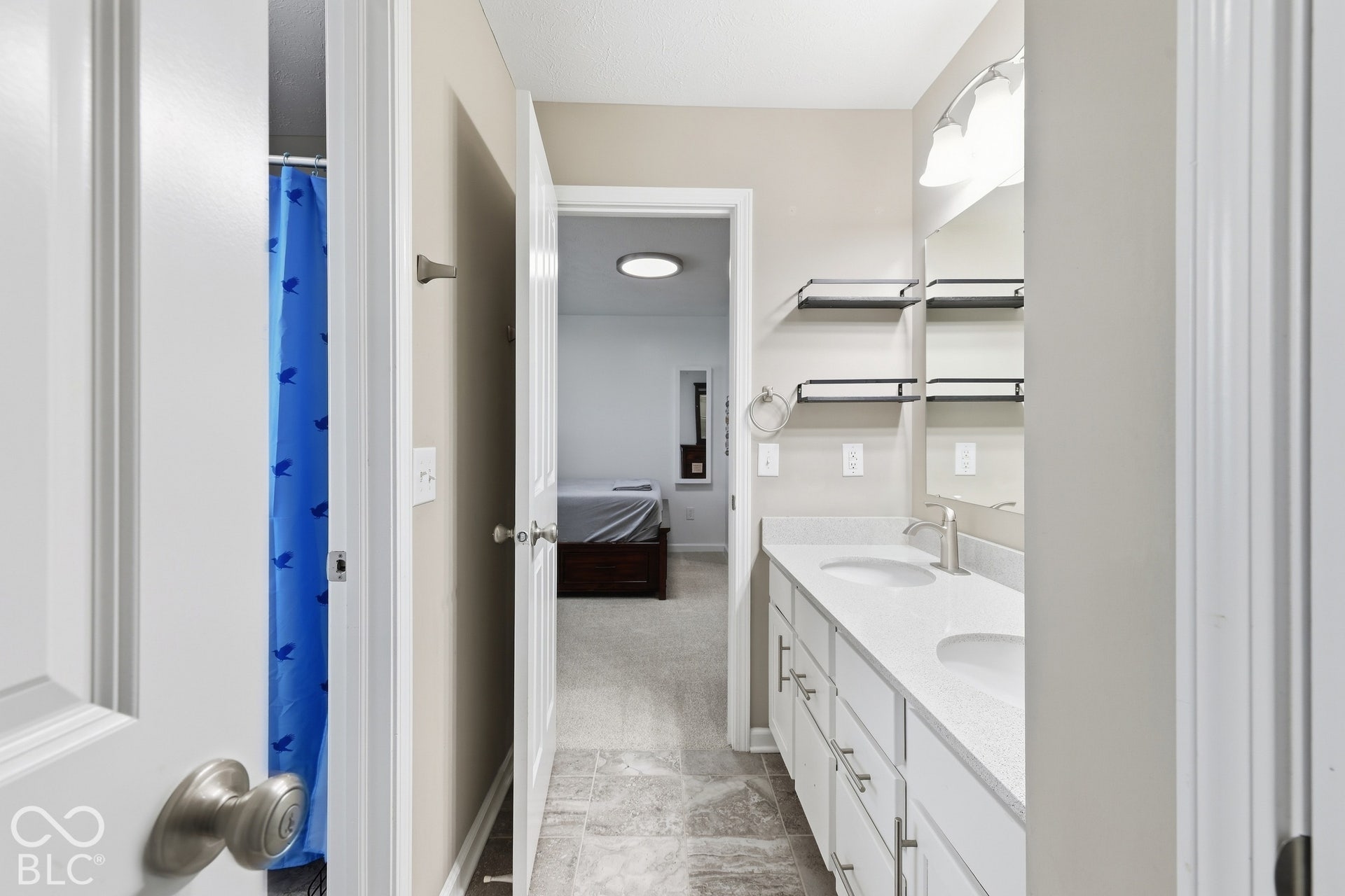 Jack & Jill bath , double vanity with white cabinetry, dual undermount sinks, and light-toned countertops