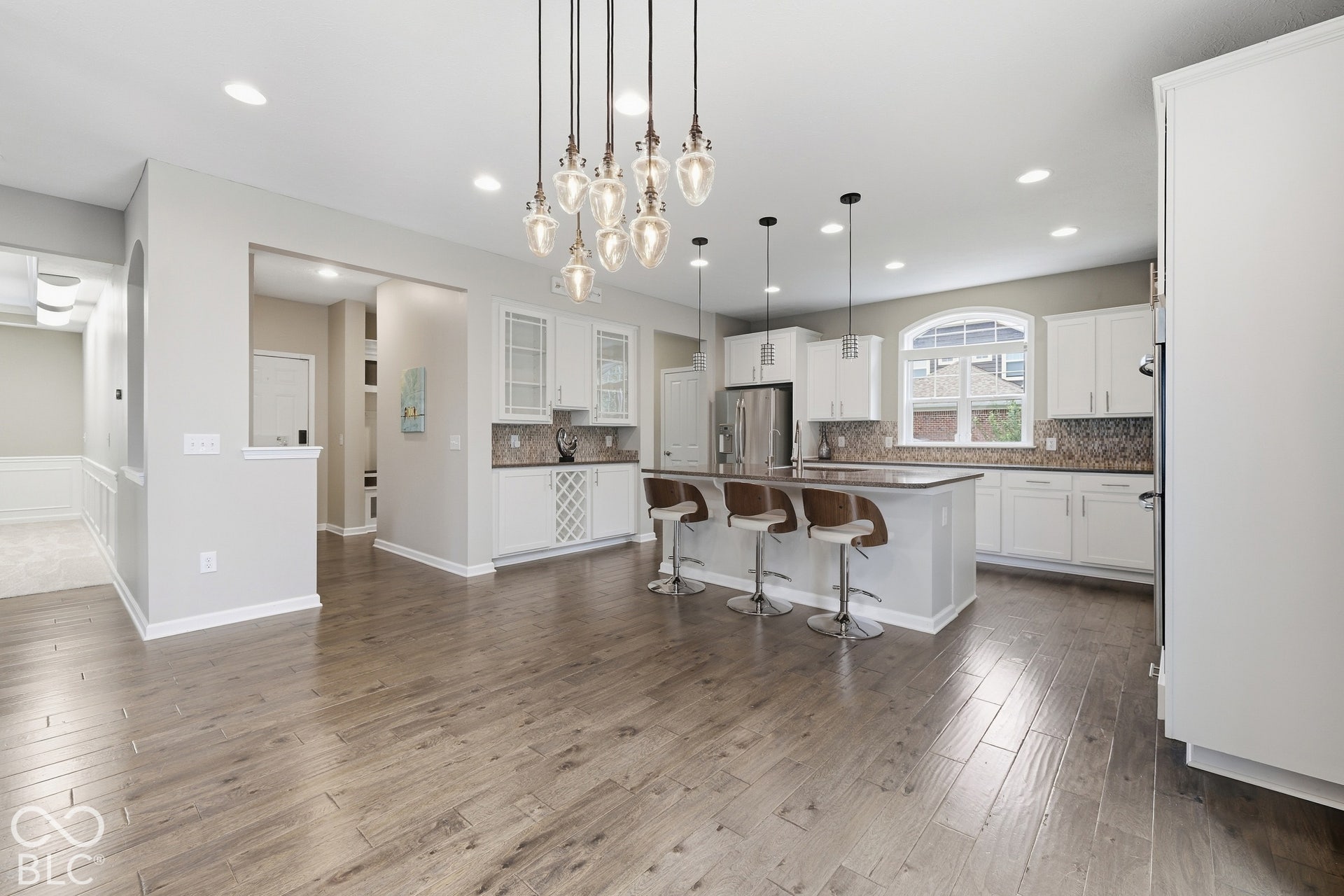 Open-concept living space featuring wood-finish flooring, recessed lighting, and a kitchen island with pendant lights
