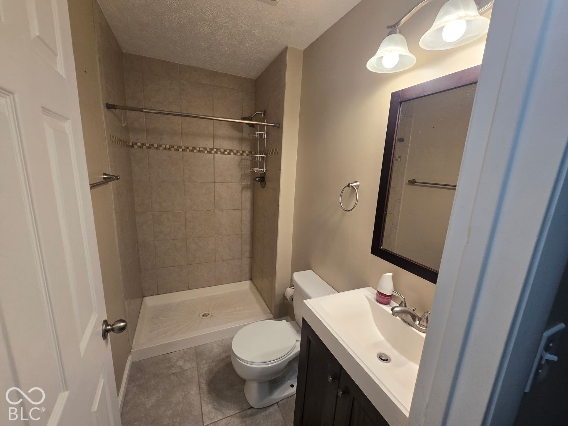 Walk-in shower with tiled surround and decorative accent band