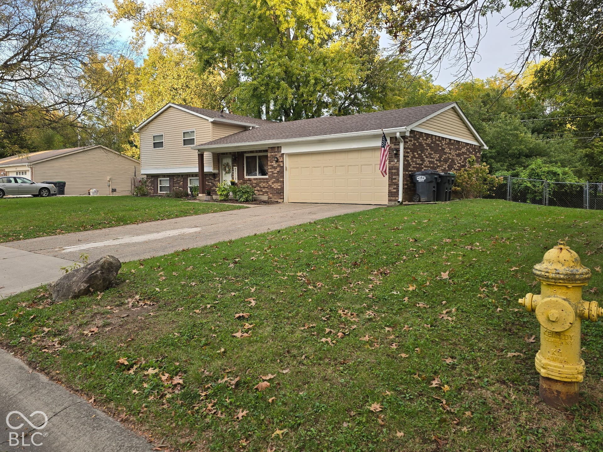 Split-level residence featuring a two-car garage, brick and siding exterior, and a concrete driveway