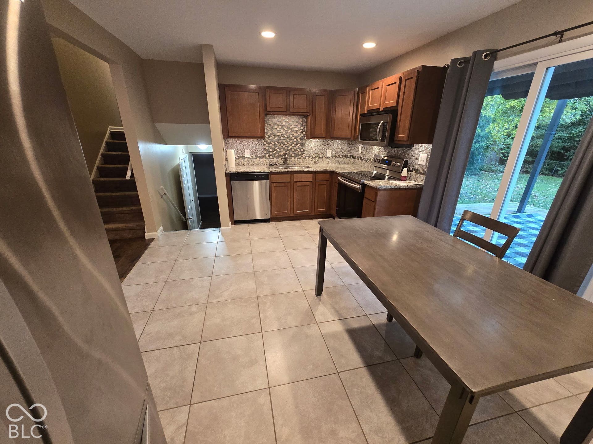 Kitchen featuring wood cabinetry, stainless steel appliances, and a tiled backsplash