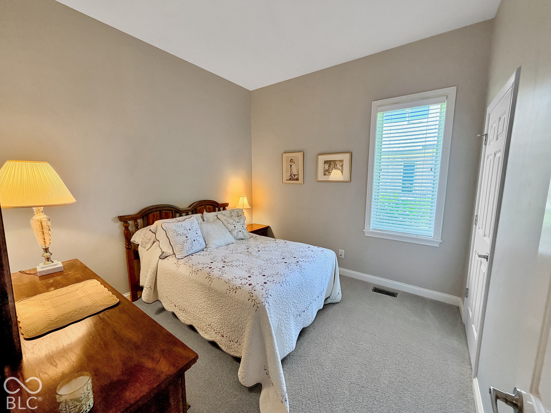 Bedroom 2 with Carpeted flooring, window with blinds, and neutral painted walls.