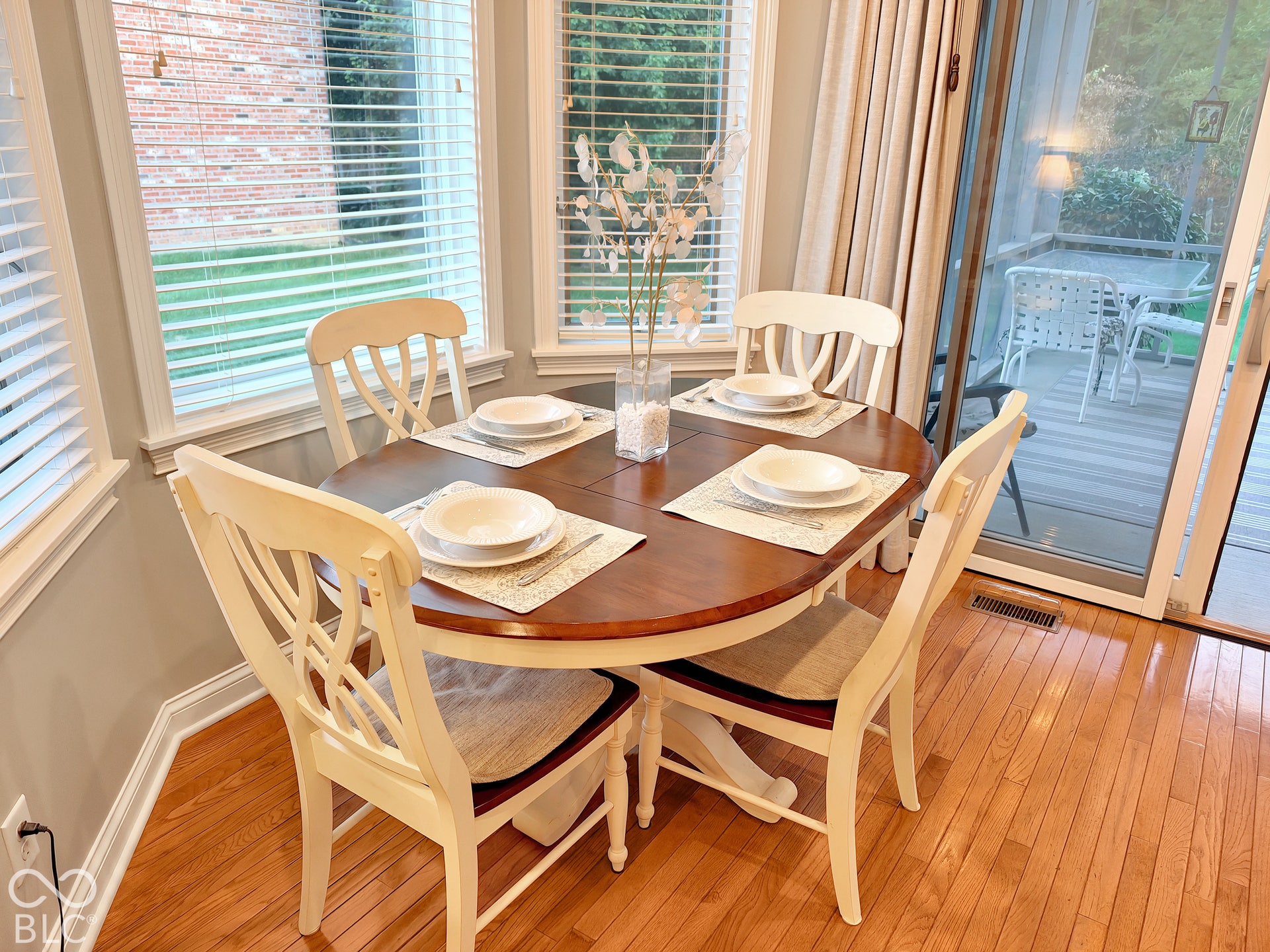 Hardwood flooring, bay window with blinds, sliding glass door opening to patio, and recessed lighting.