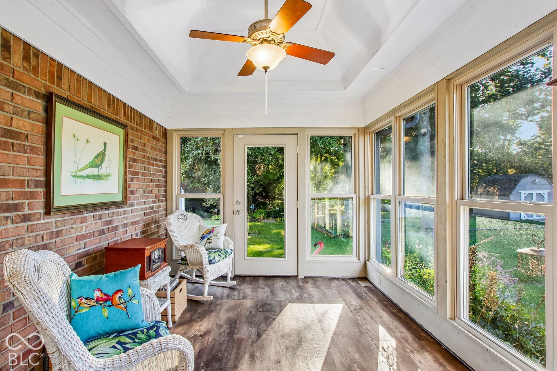 View of updated fully enclosed, heated and cooled sunroom with ceiling fan