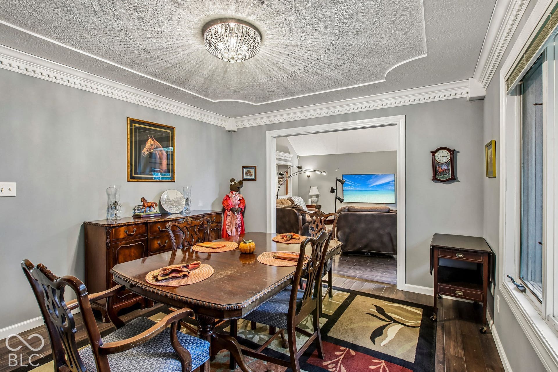 View of dining room with decorative inset ceiling, bay window and updated laminate hardwood flooring