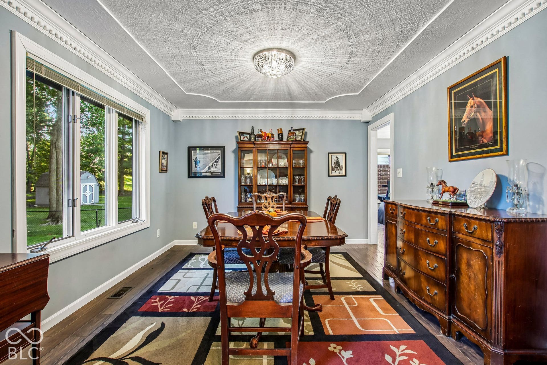 View of dining room with decorative inset ceiling, bay window and updated laminate hardwood flooring