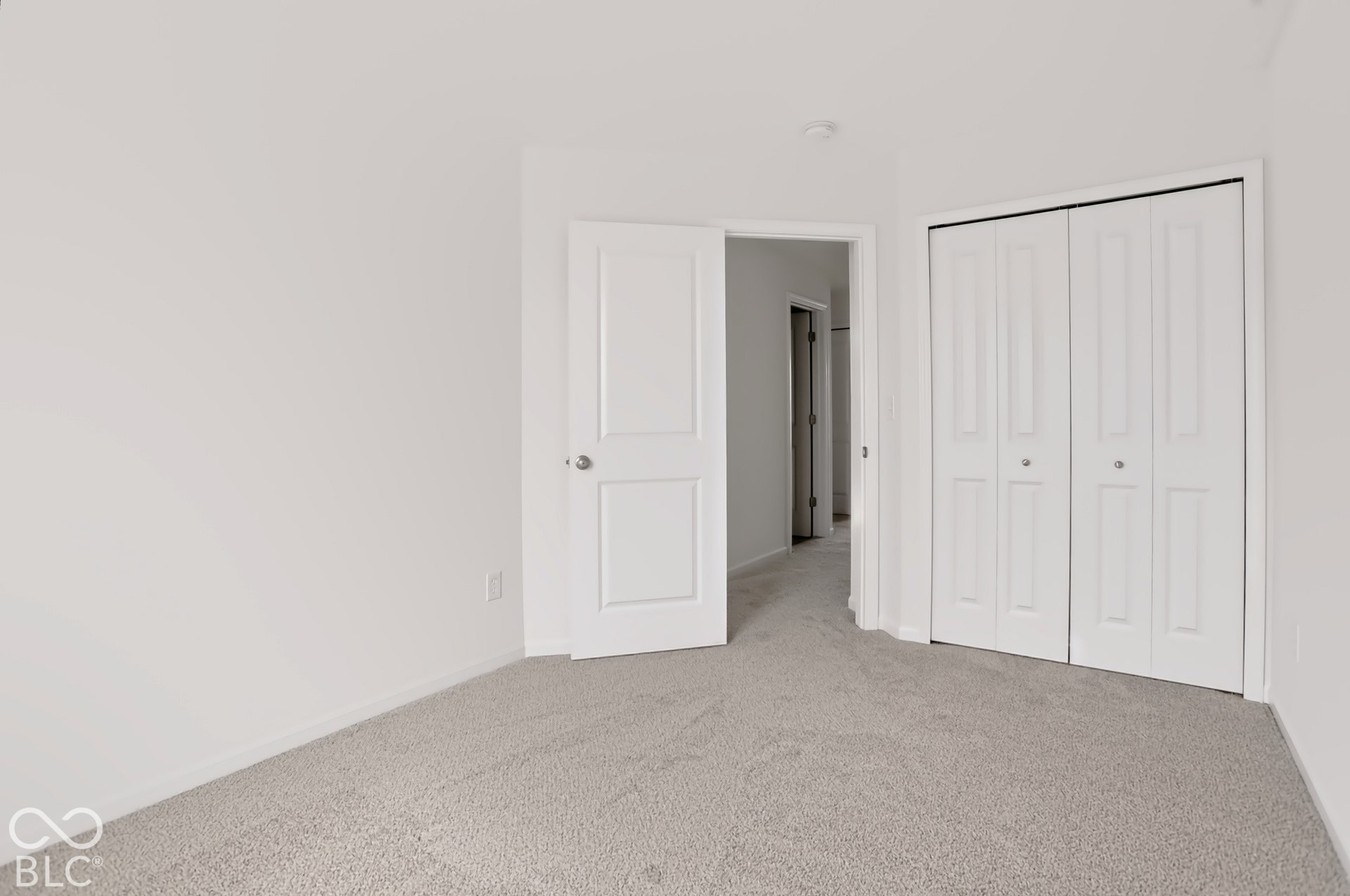 Plush carpet flooring, white interior doors, and bi-fold closet doors