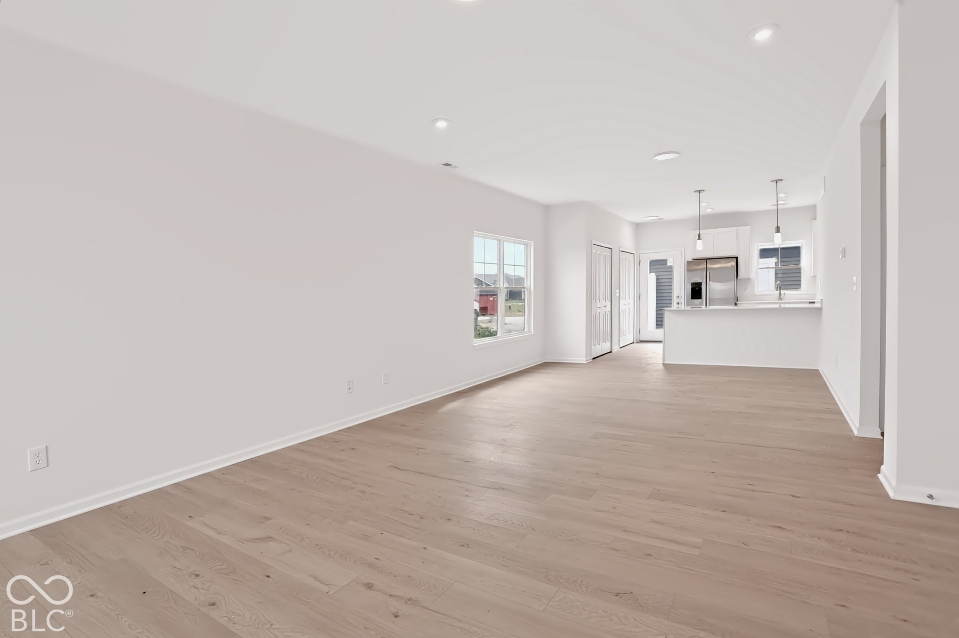 Open-concept living area featuring wood-finish flooring and recessed lighting