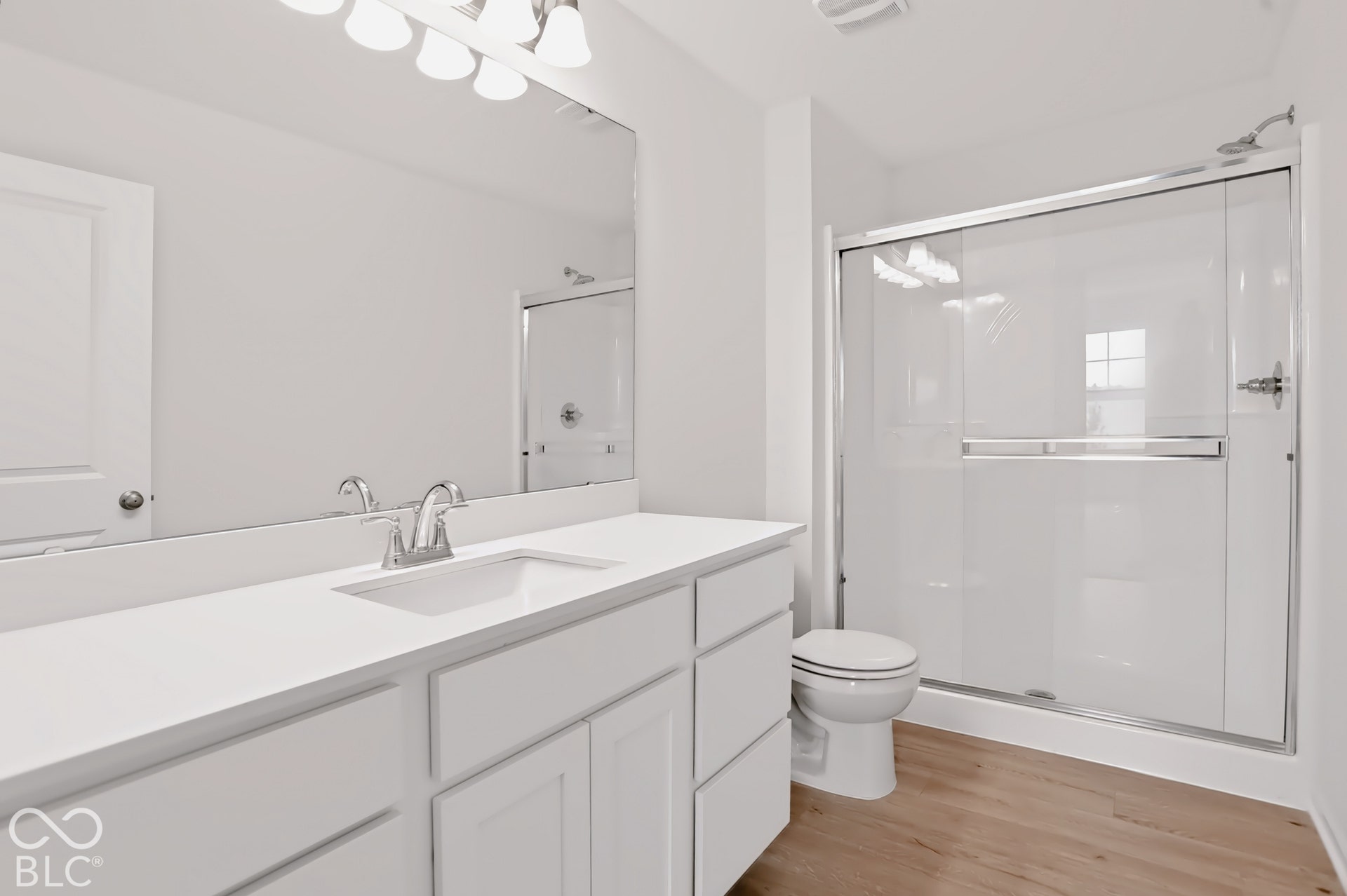 White vanity with an integrated sink, polished chrome faucet, and expansive mirror