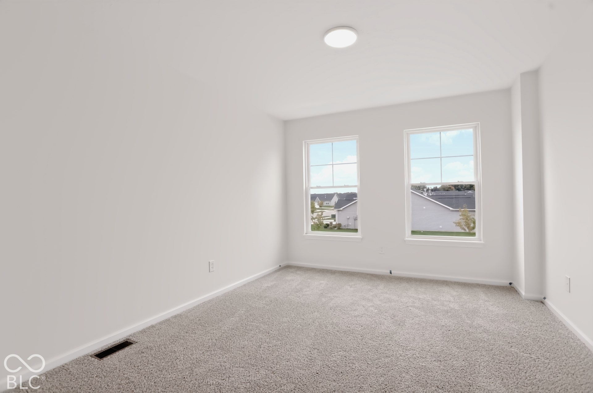 Light gray carpeting throughout, white walls, and two double-hung windows