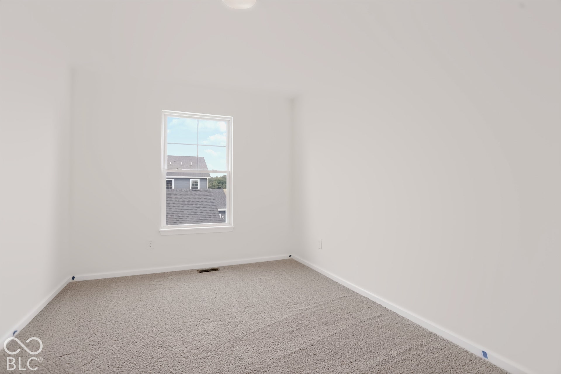 Neutral wall paint, light-toned carpeting, and a window with white trim