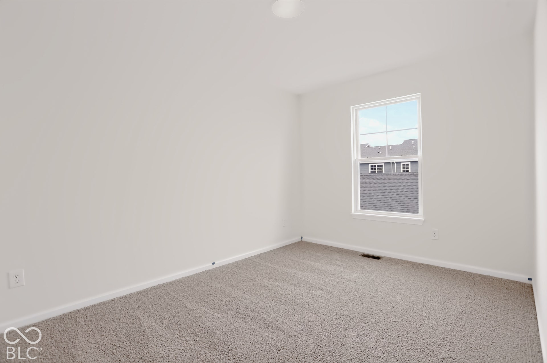 Neutral wall color, light-toned carpet flooring, and a window with white trim